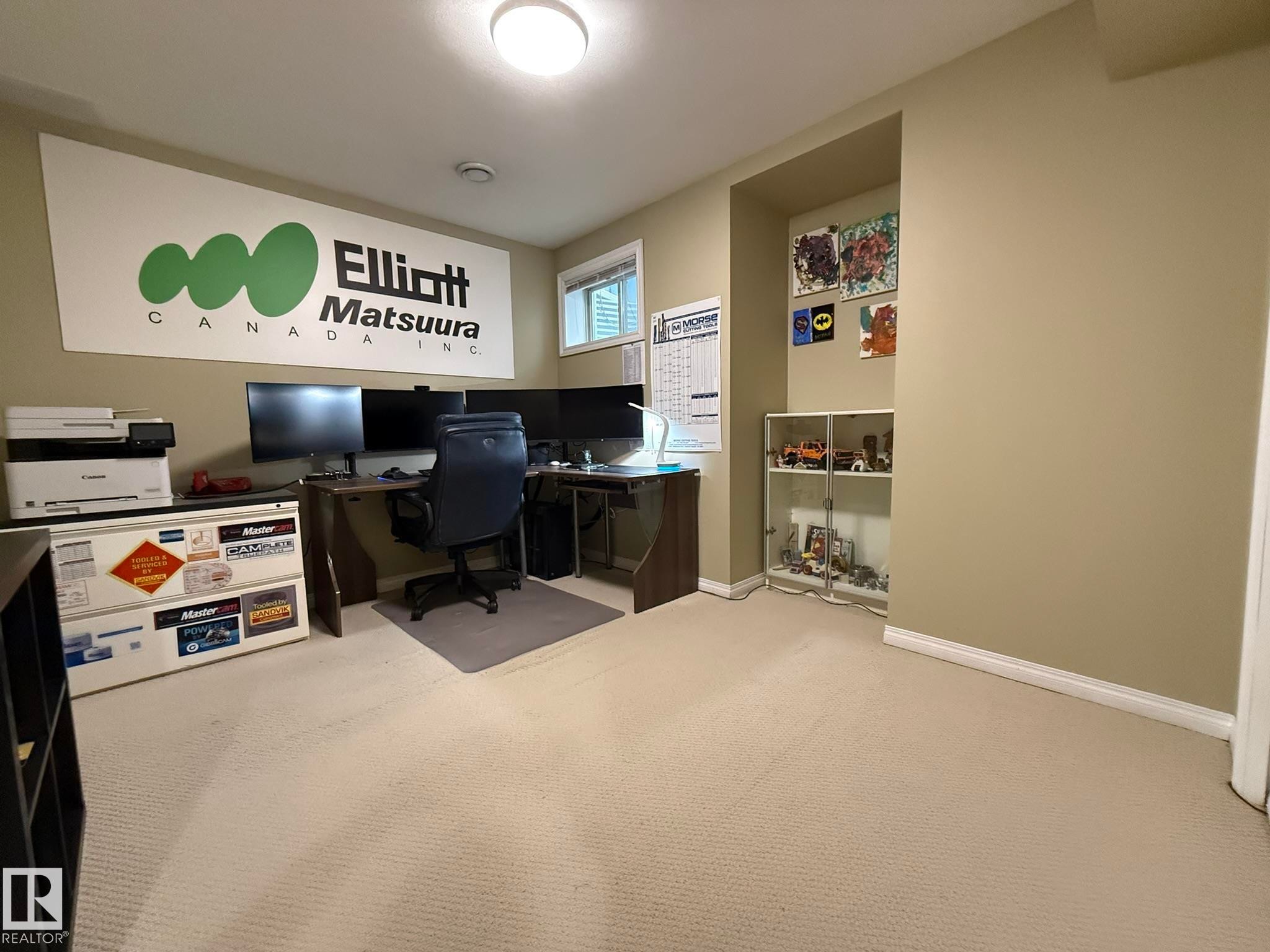 Carpeted room featuring a built-in wall niche with shelving, a ceiling-mounted light fixture, and a window with blinds - 1820 Robertson Crescent Sw, Edmonton, AB - Indoor Photo Showing Office