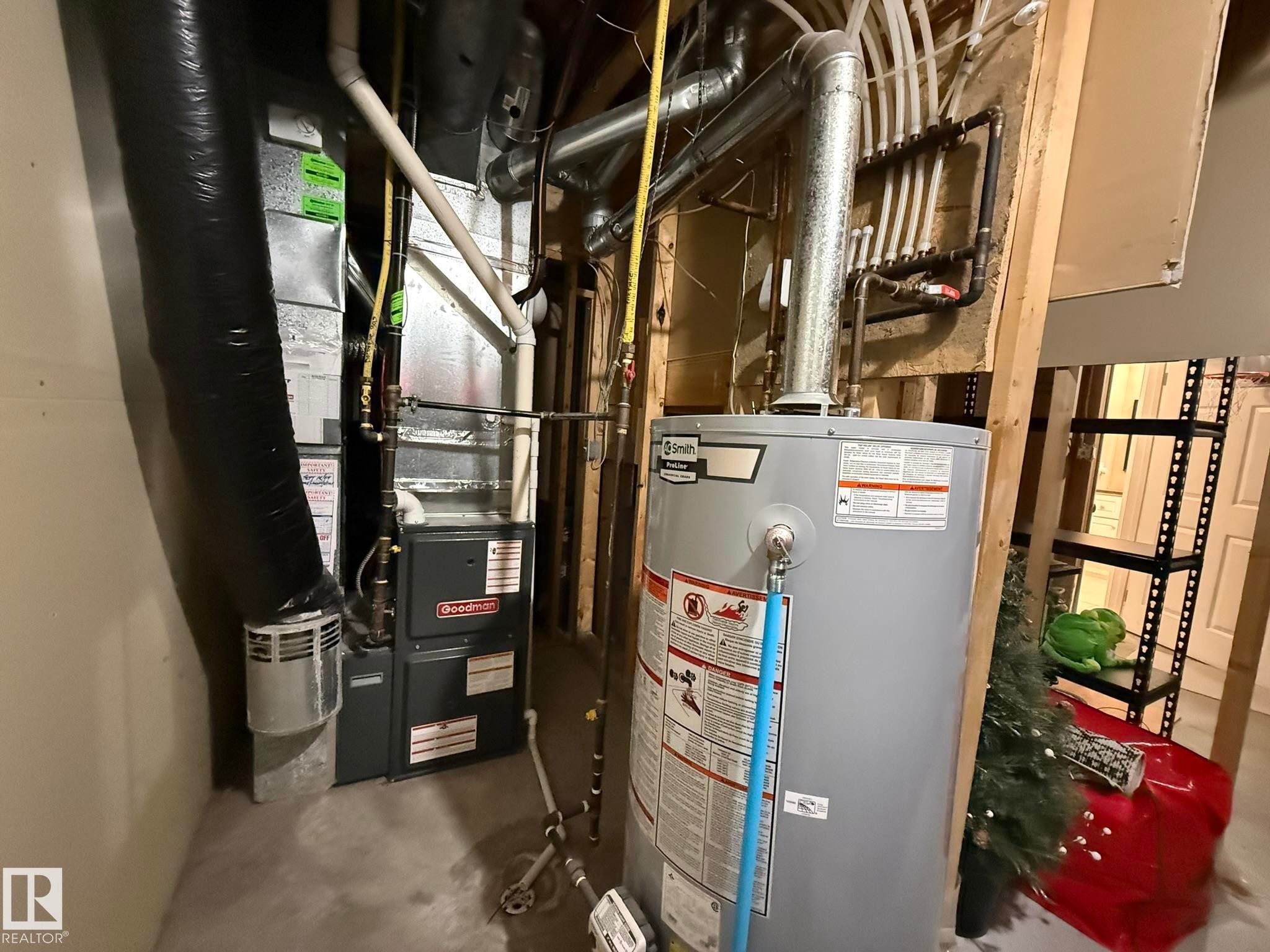Goodman furnace with associated ductwork, water heater, and PEX plumbing manifold - 1820 Robertson Crescent Sw, Edmonton, AB - Indoor Photo Showing Basement