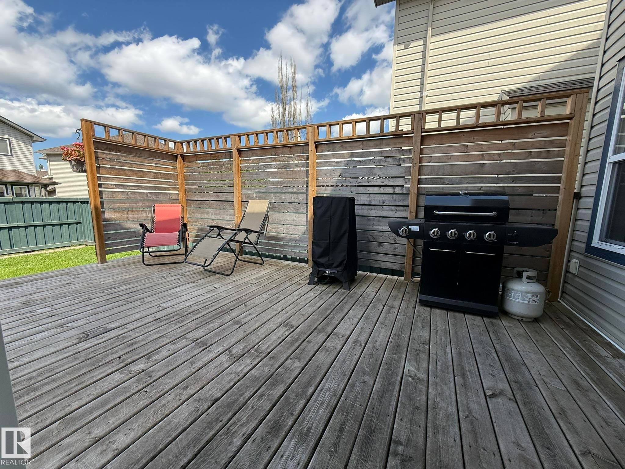 Spacious wooden deck with slatted wood privacy fencing - 1820 Robertson Crescent Sw, Edmonton, AB - Outdoor With Deck Patio Veranda