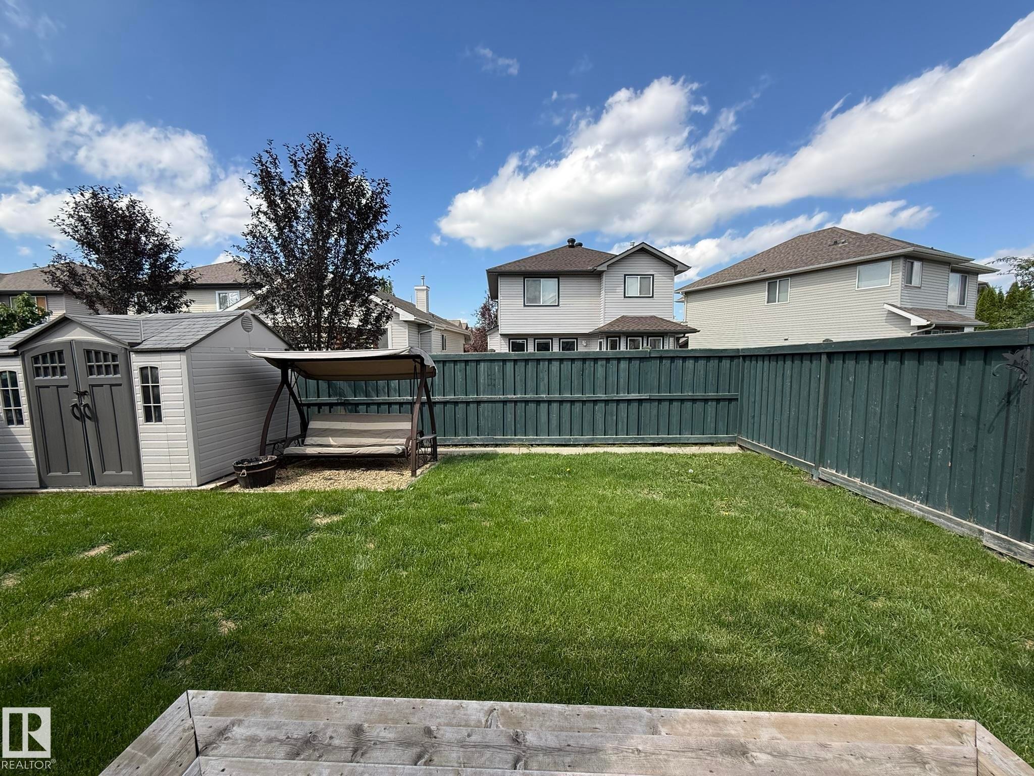 Spacious backyard featuring a substantial lawn area, a privacy fence, and a storage shed - 1820 Robertson Crescent Sw, Edmonton, AB - Outdoor