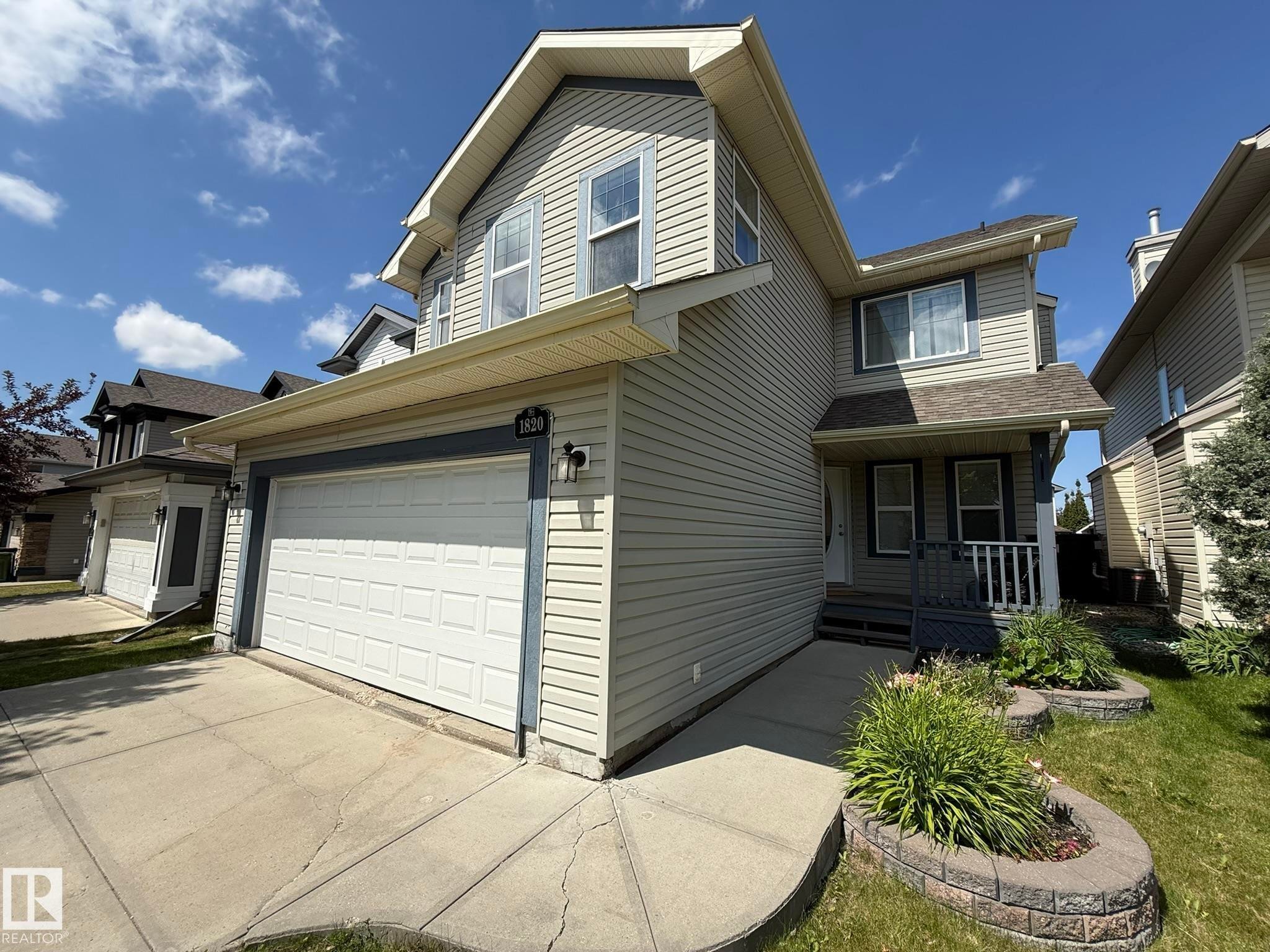 Two-story residence featuring light-toned siding and a prominent attached two-car garage - 1820 Robertson Crescent Sw, Edmonton, AB - Outdoor