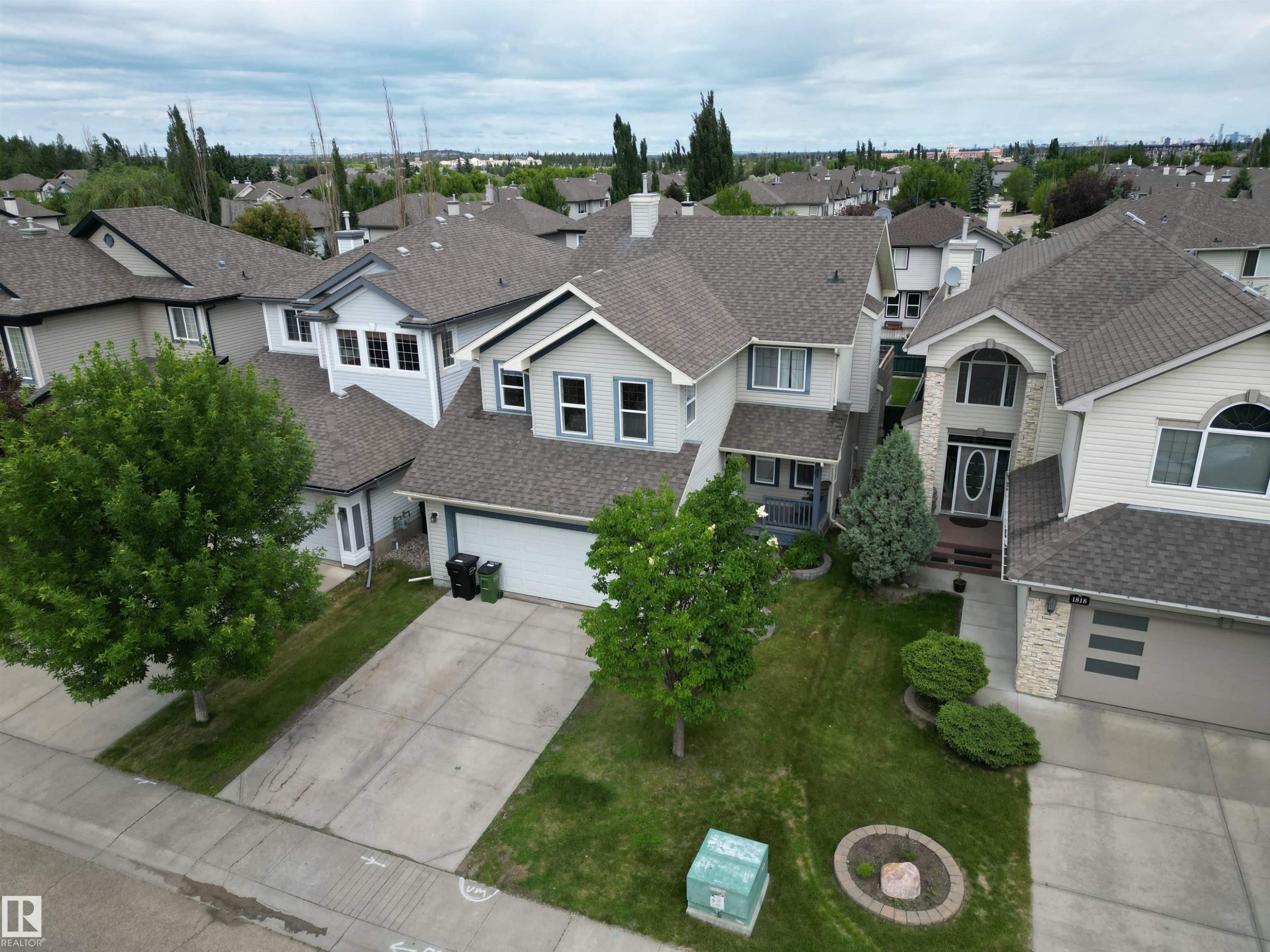 Two-story residence featuring light-toned siding, a dark shingle roof, and an attached two-car garage - 1820 Robertson Crescent Sw, Edmonton, AB - Outdoor With Facade