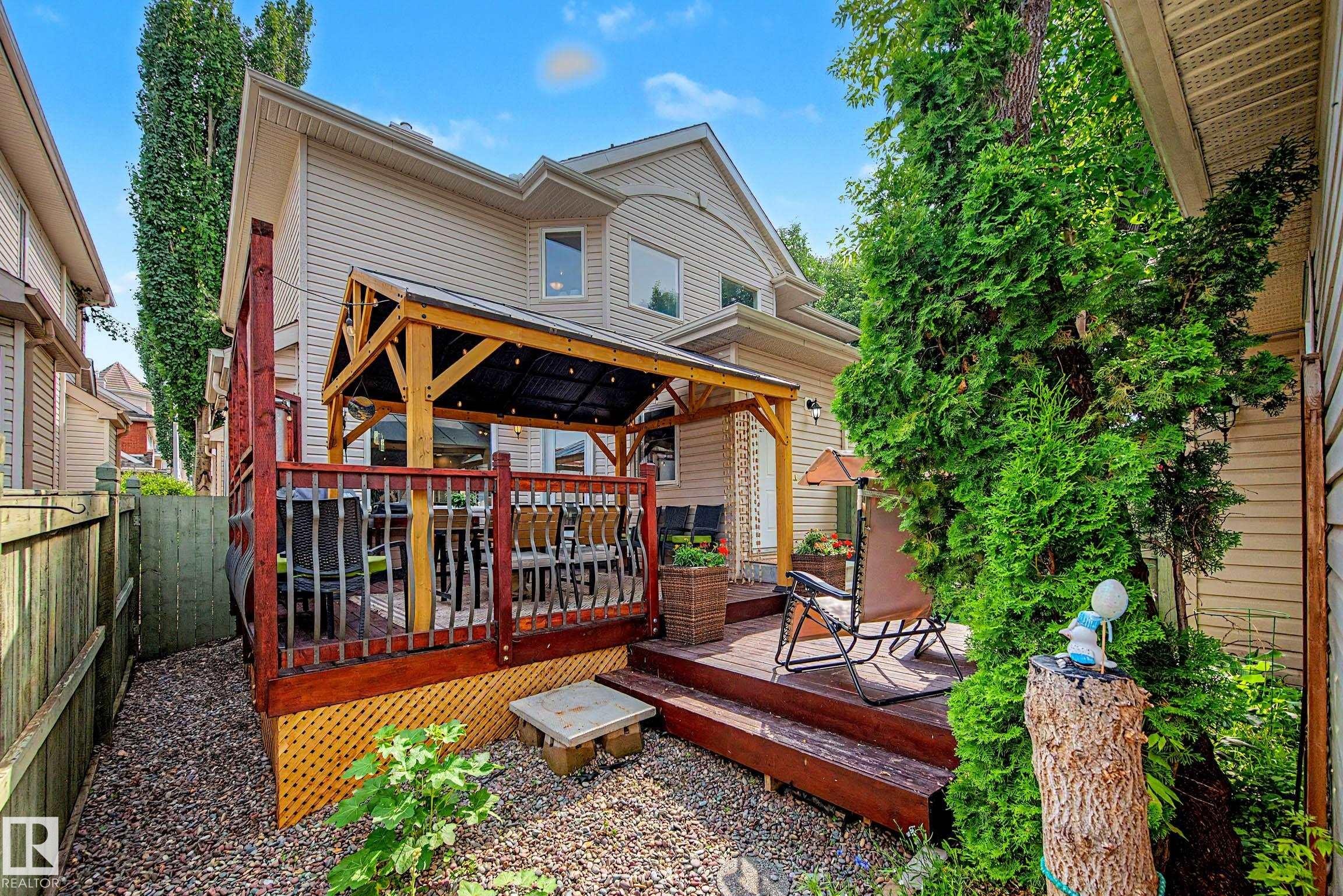 Rear exterior featuring a multi-level wood deck with a covered pergola - 9130 100A Avenue Nw, Edmonton, AB - Outdoor With Deck Patio Veranda With Exterior