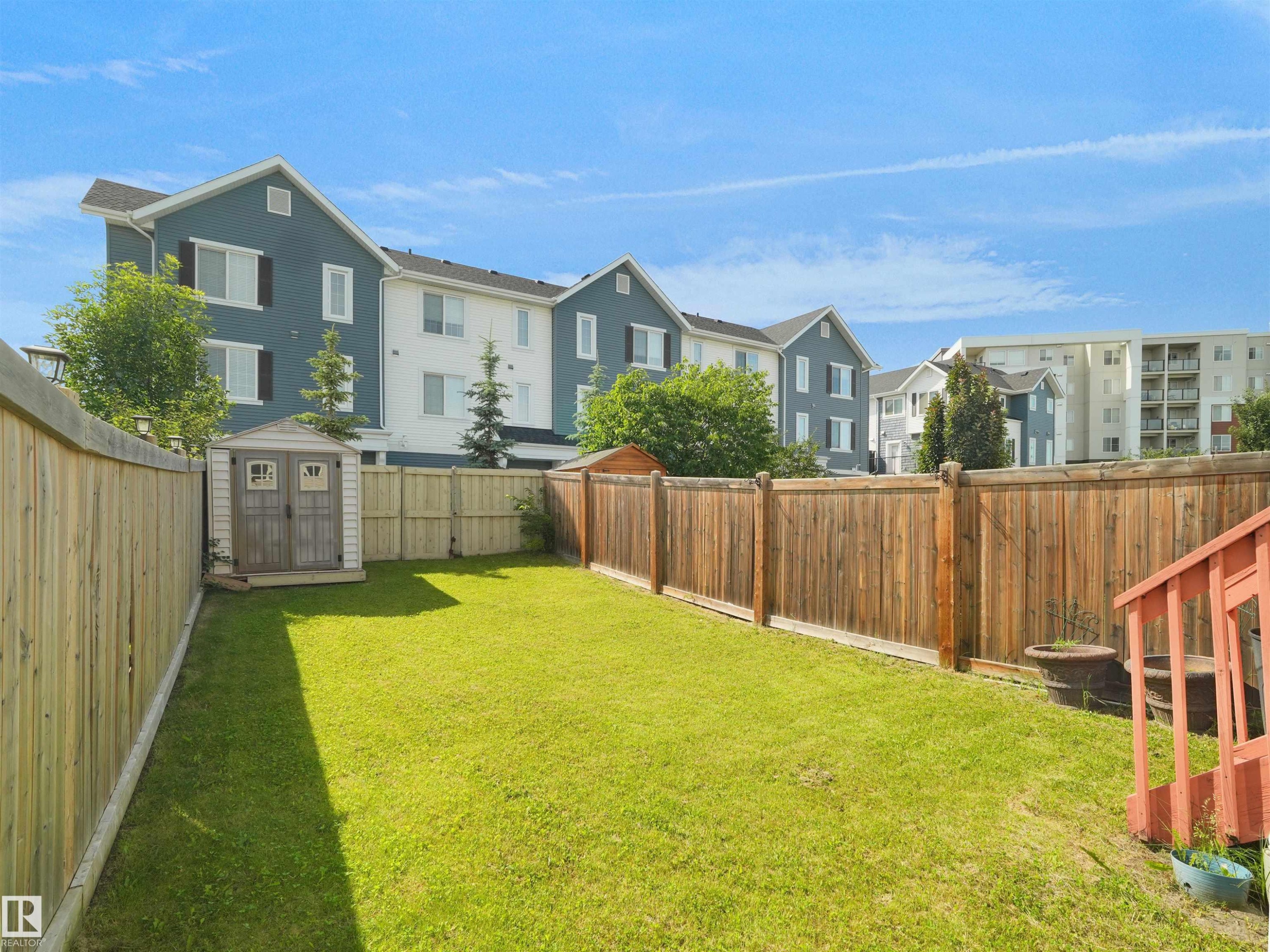 Expansive fenced backyard featuring a manicured lawn, a storage shed, and a privacy fence - 4487 Annett Common Sw, Edmonton, AB - Outdoor