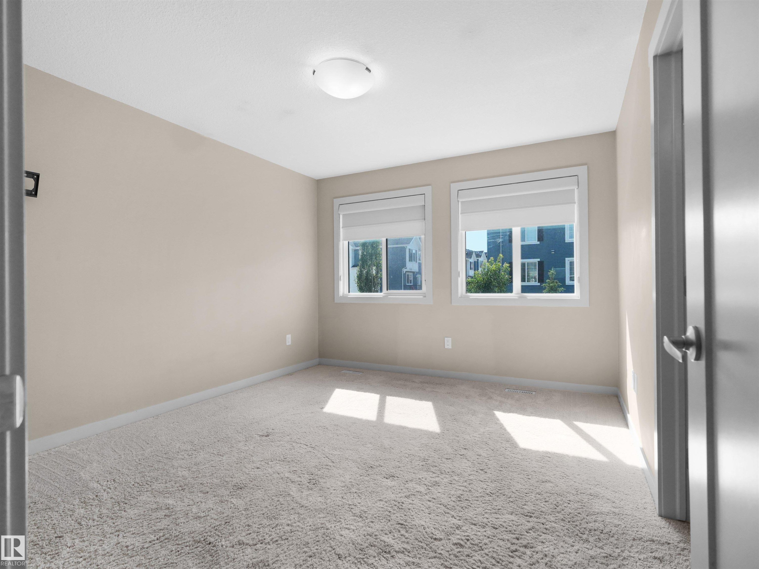 Neutral-toned room featuring light beige walls and light gray carpeting - 4487 Annett Common Sw, Edmonton, AB - Indoor Photo Showing Other Room