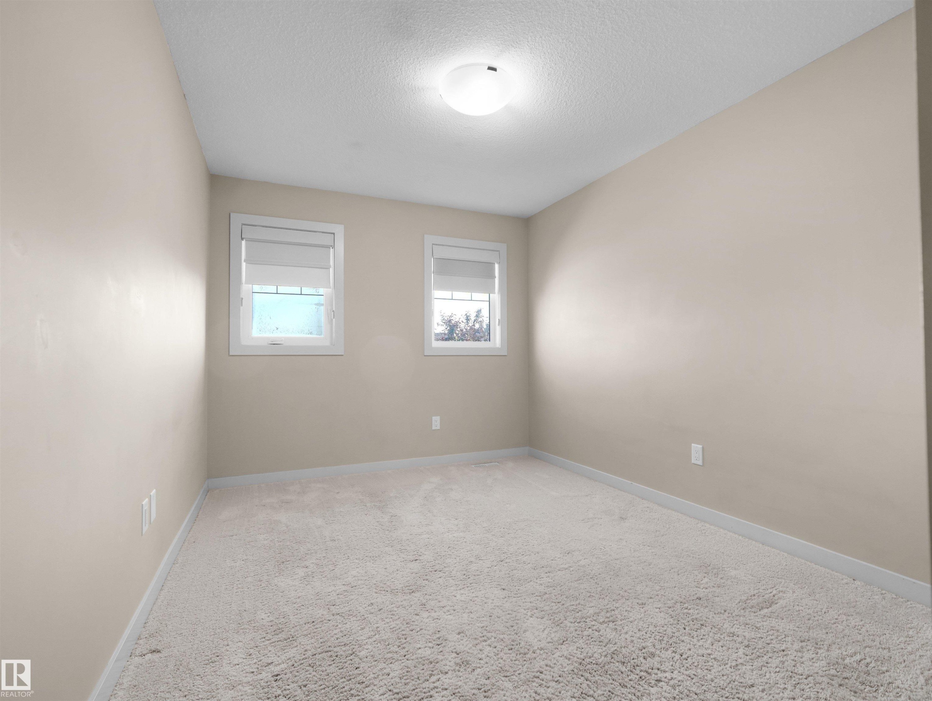 Neutral-toned room featuring light-colored walls and plush carpet flooring - 4487 Annett Common Sw, Edmonton, AB - Indoor Photo Showing Other Room