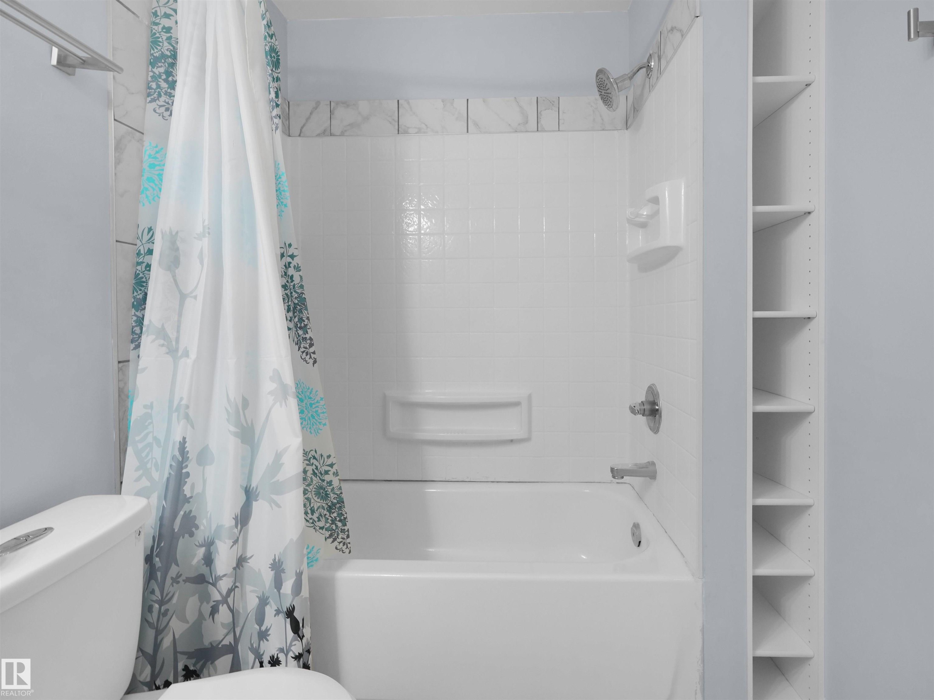 White tiled shower and bathtub combination with chrome fixtures - 4487 Annett Common Sw, Edmonton, AB - Indoor Photo Showing Bathroom