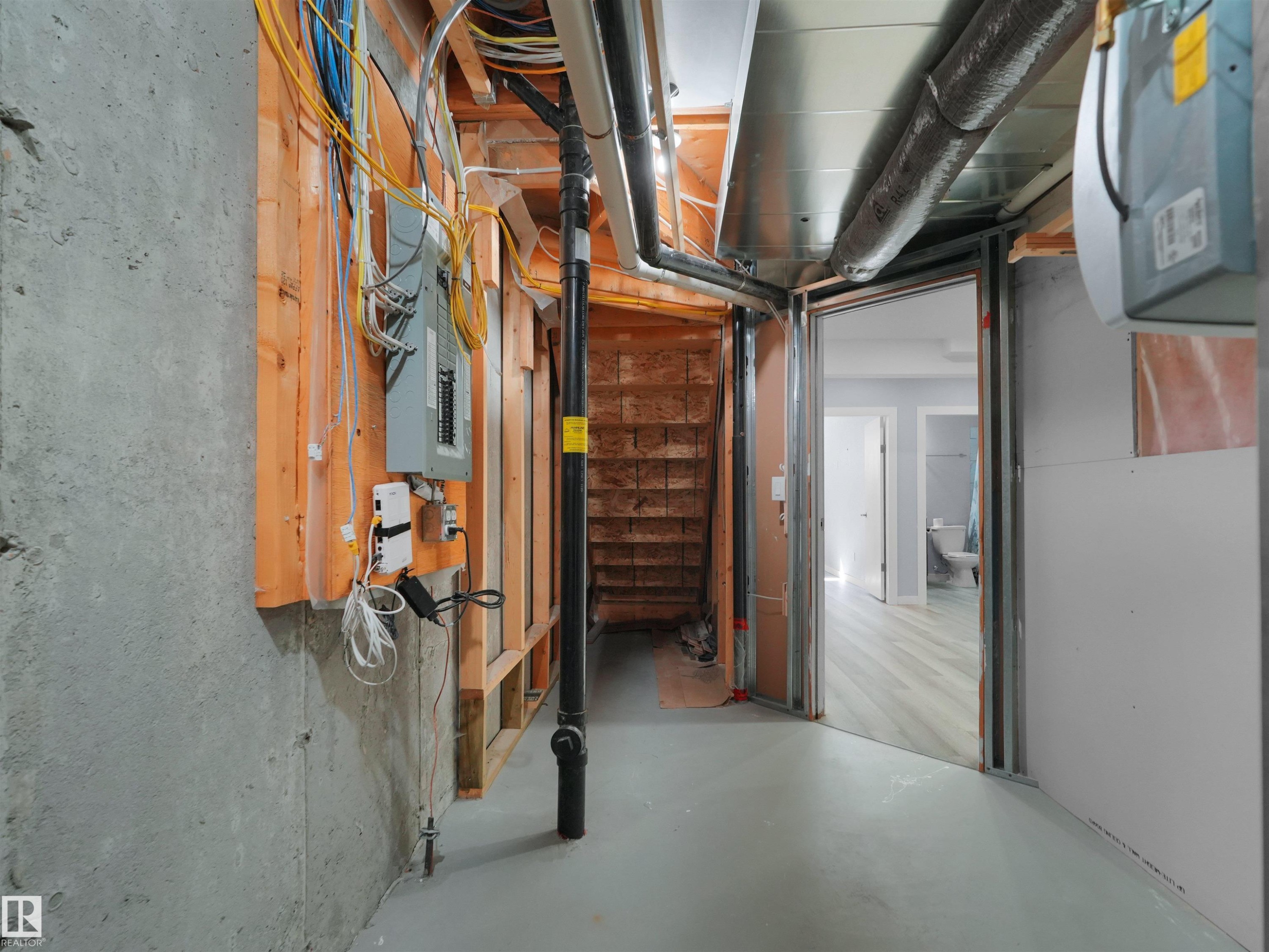 Unfinished basement space featuring exposed concrete walls and ceiling joists - 4487 Annett Common Sw, Edmonton, AB - Indoor Photo Showing Basement