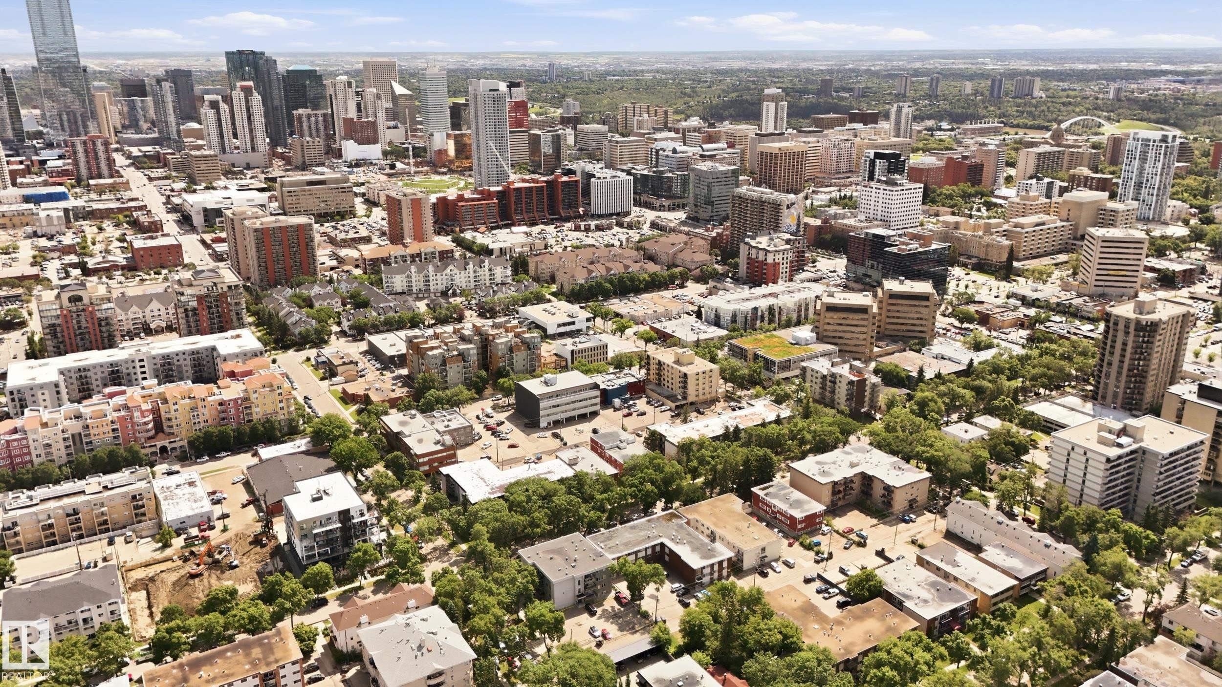 Expansive urban landscape featuring a mix of high-rise and mid-rise buildings, extensive tree canopy, and diverse architectural styles - #433 11217 103 Av Nw, Edmonton, AB - Outdoor With View