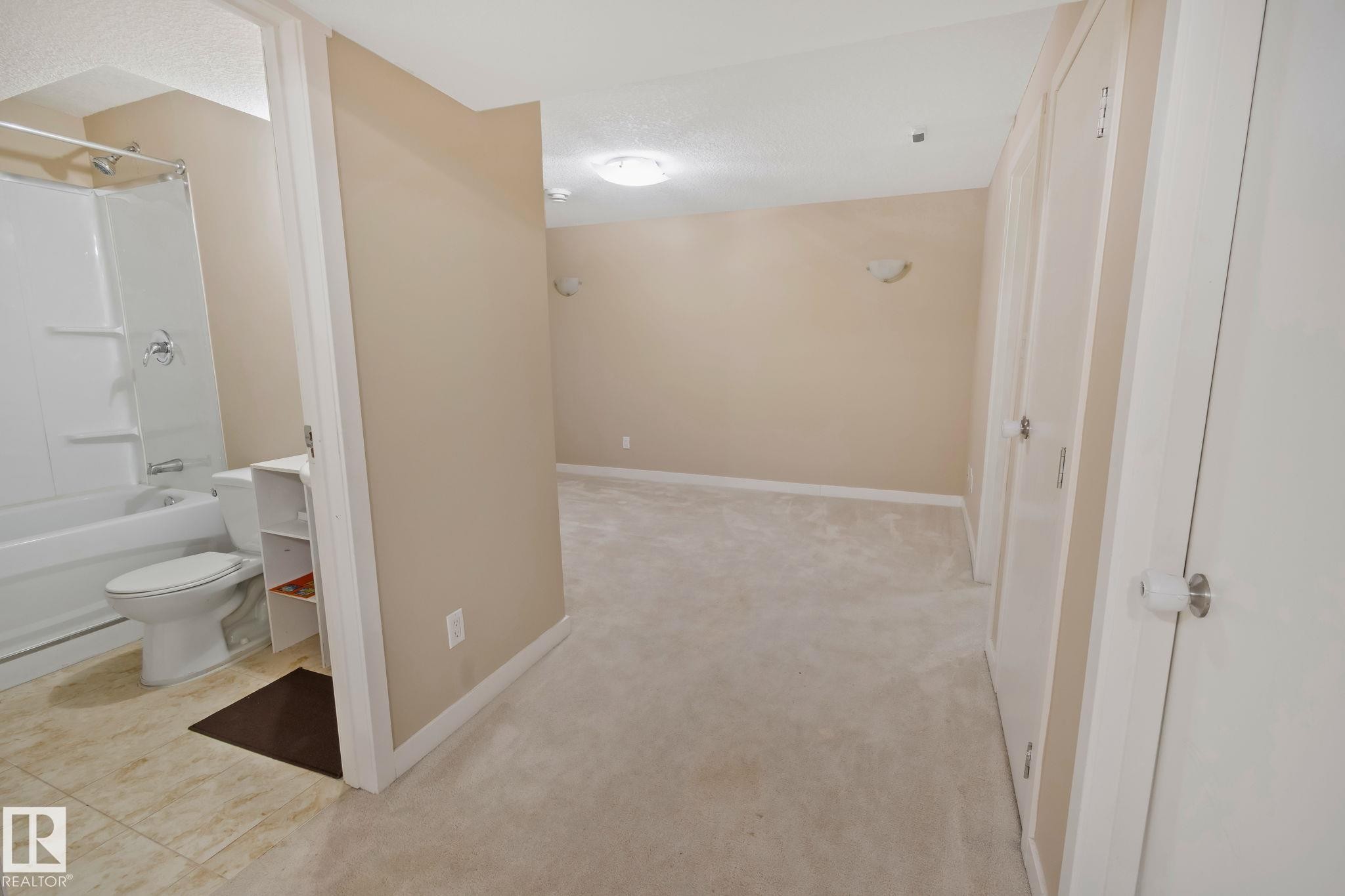 Well-lit room featuring neutral-toned walls, carpeted flooring, and white trim - 1115 61 Street Sw, Edmonton, AB
