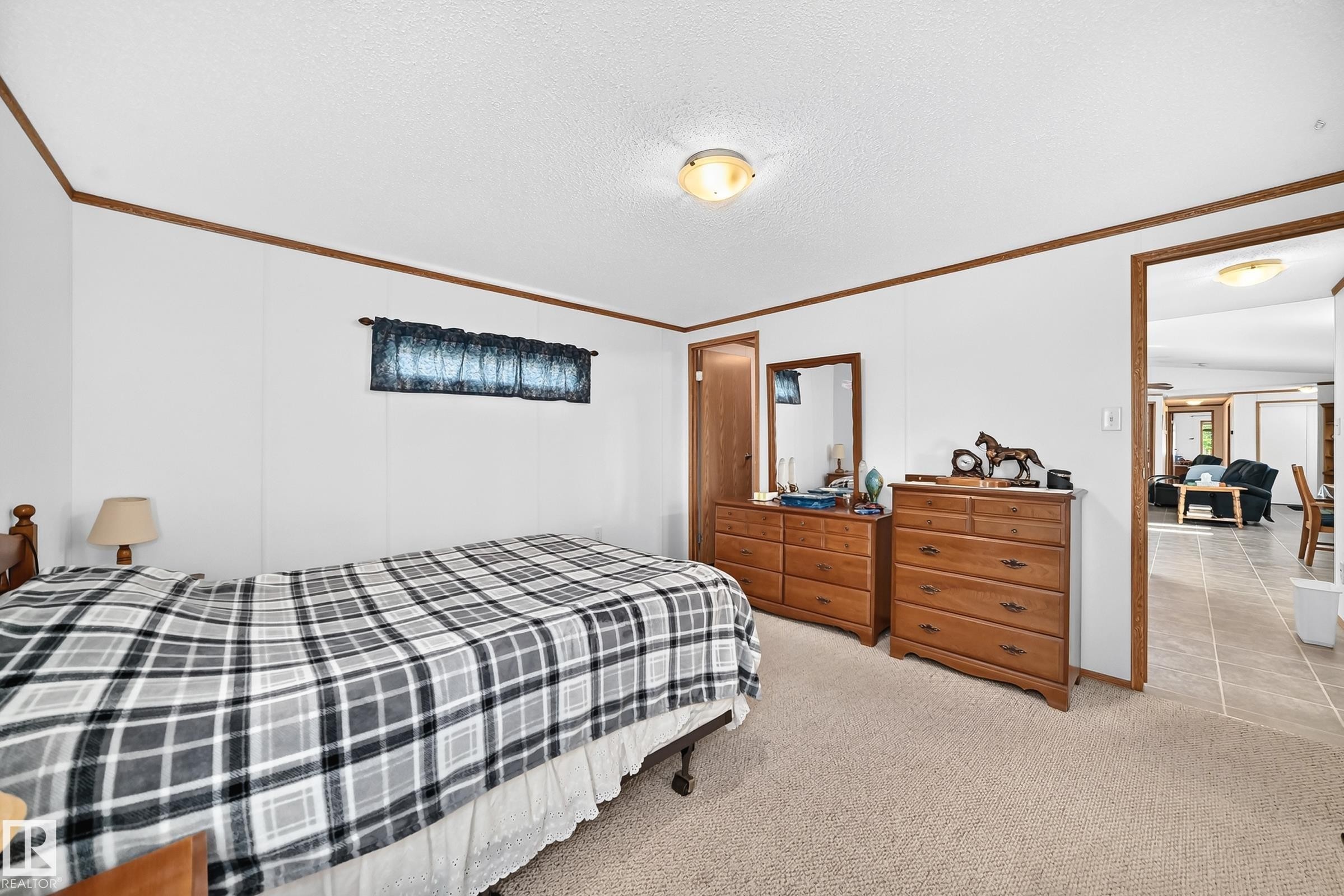 Carpeted bedroom with white walls and wood-finish trim - #225 3400 48 St, Stony Plain, AB - Indoor Photo Showing Bedroom