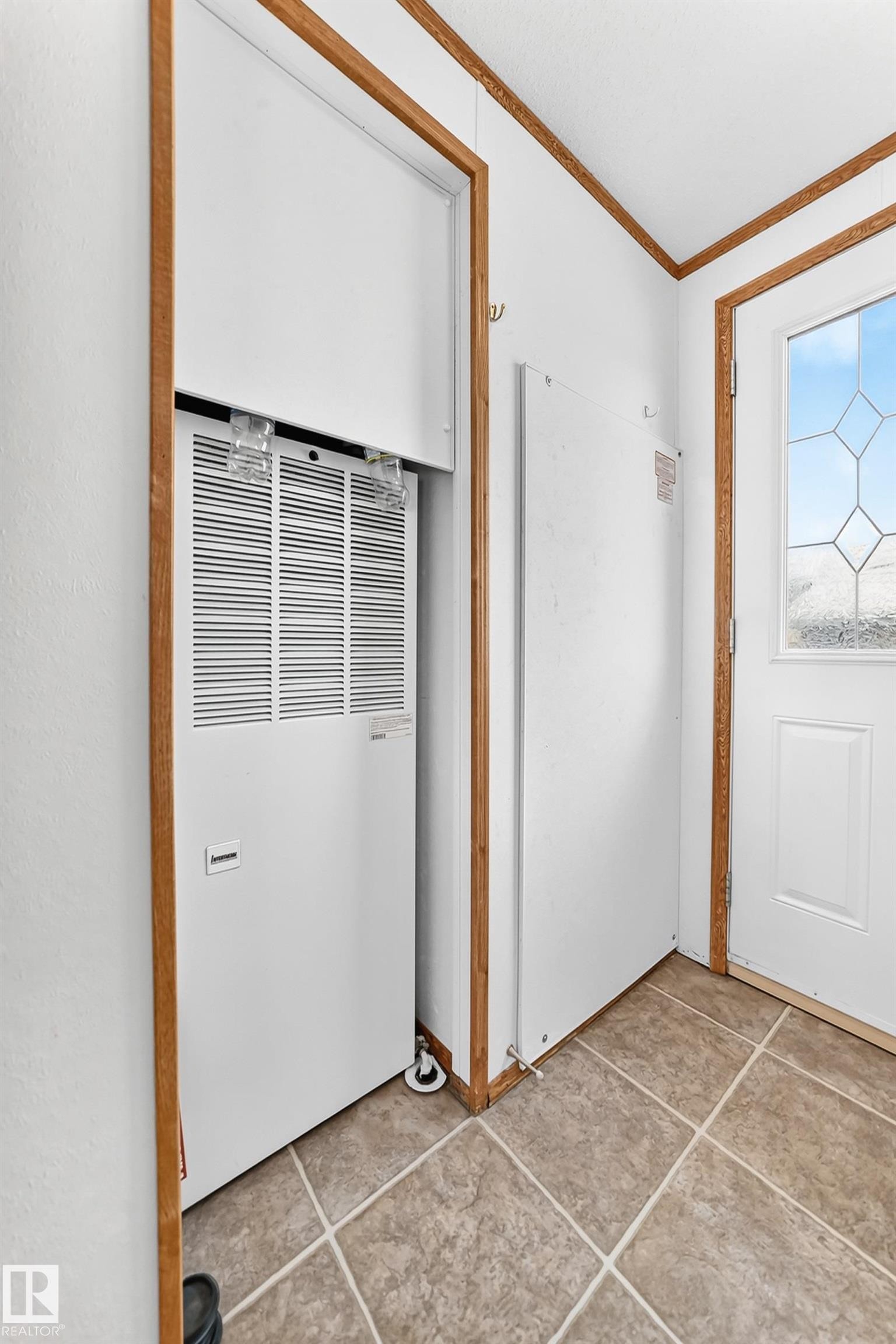 Utility closet featuring a white furnace unit with a visible air intake vent, accompanied by a white electrical panel - #225 3400 48 St, Stony Plain, AB - Indoor Photo Showing Other Room