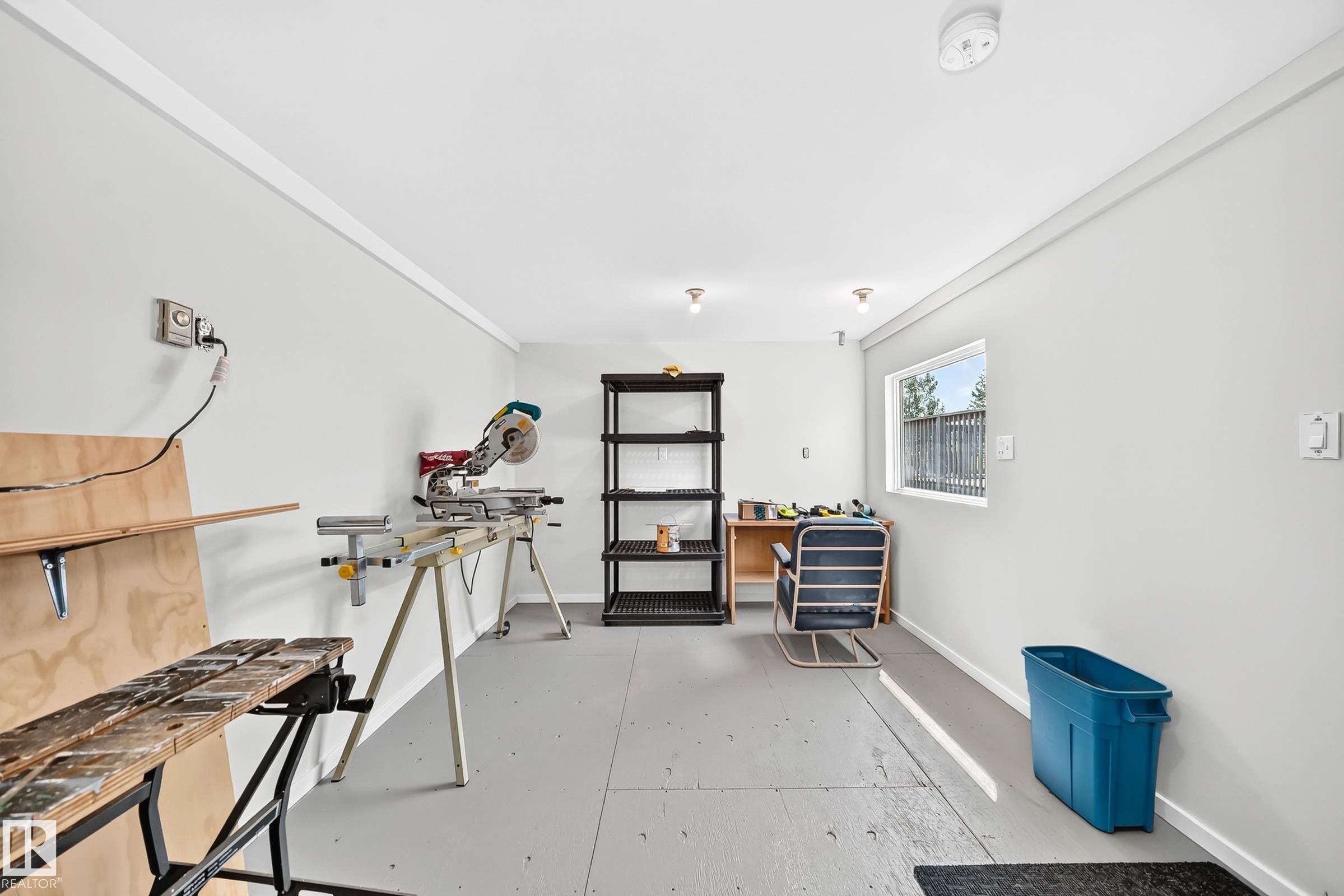 White painted walls and ceiling with trim molding, featuring light gray flooring - #225 3400 48 St, Stony Plain, AB - Indoor Photo Showing Gym Room