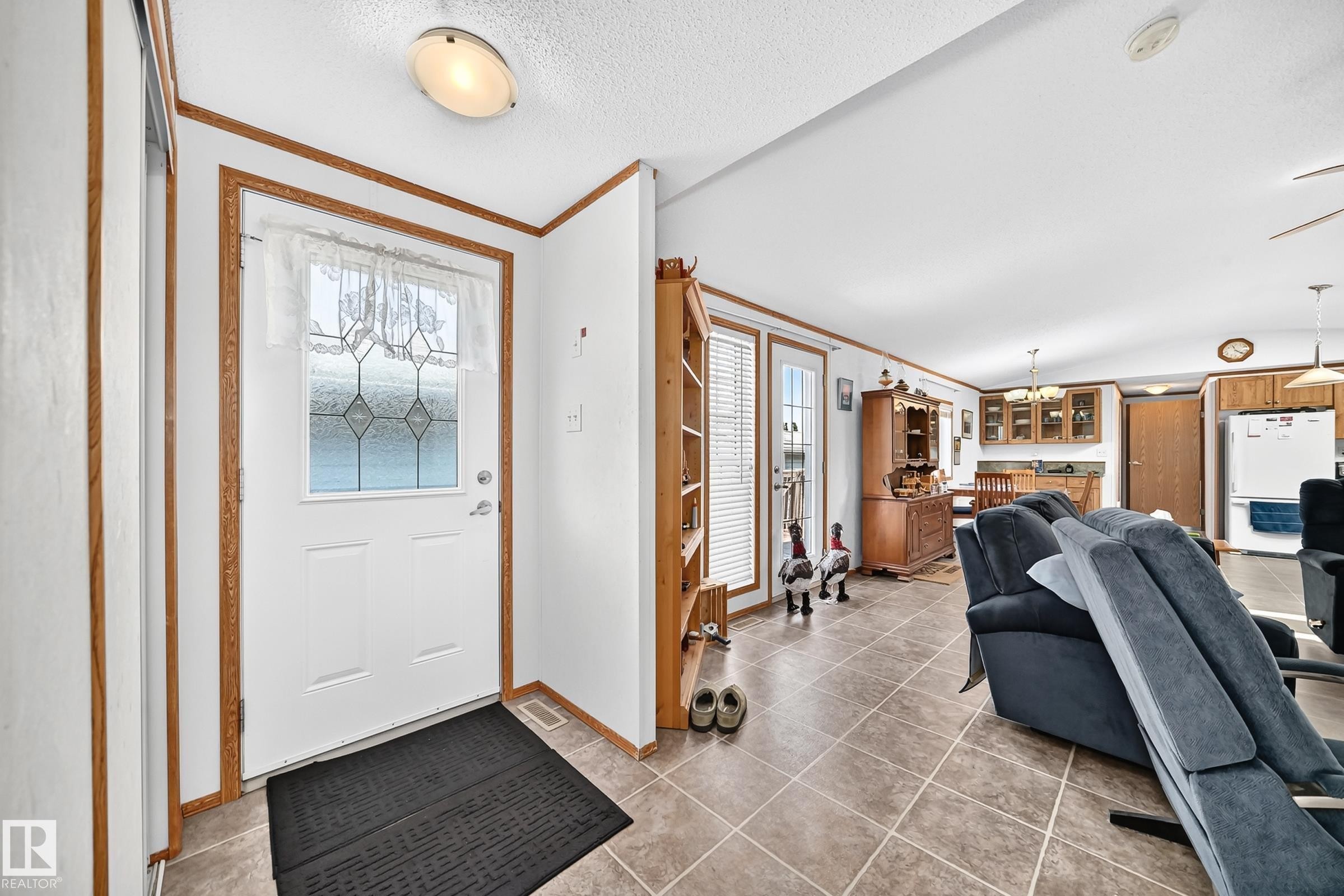 Entryway featuring a white door with decorative glass inserts, wood-finish trim, and a flush-mount ceiling light - #225 3400 48 St, Stony Plain, AB - Indoor Photo Showing Other Room