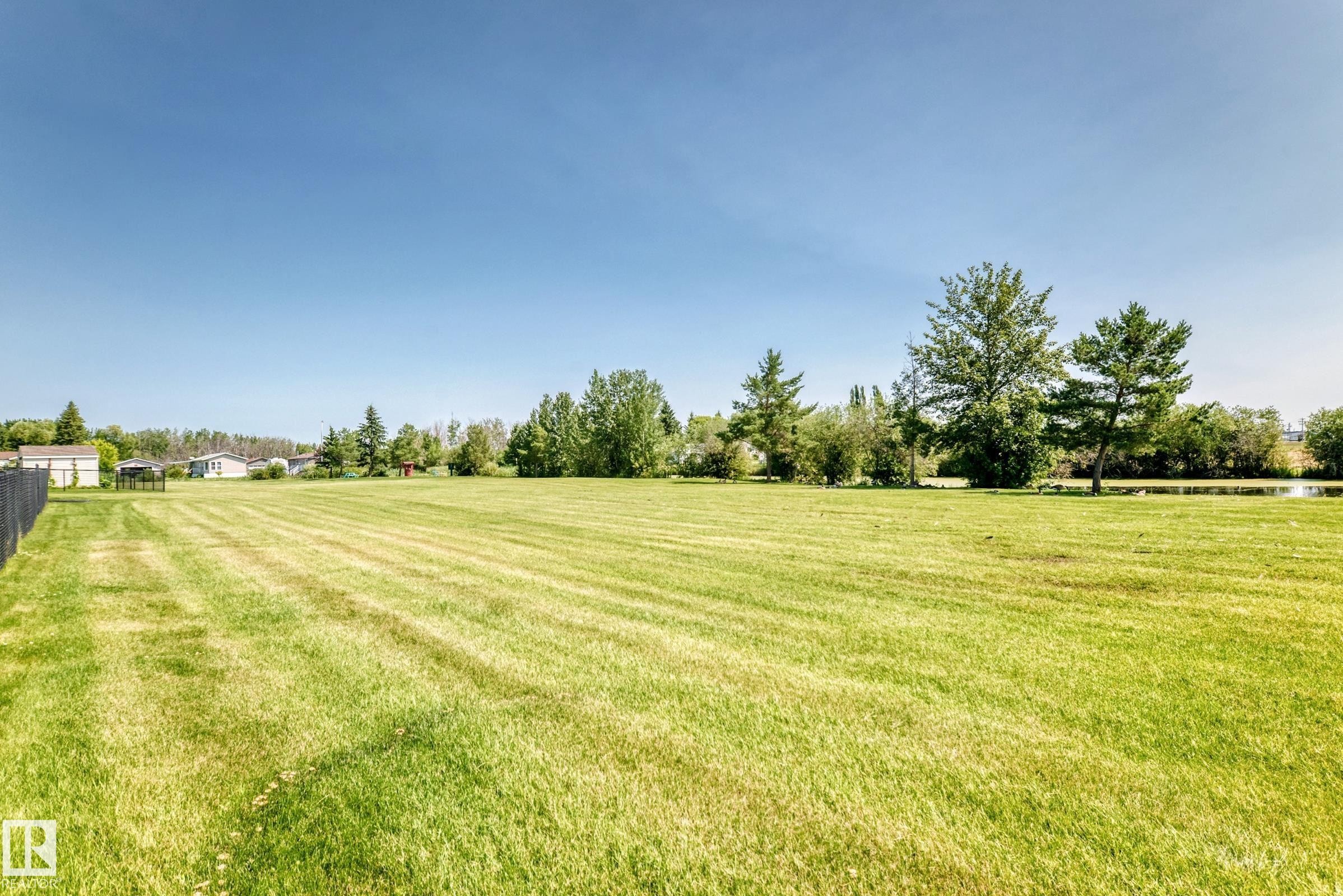Expansive grassy field with a perimeter fence - #225 3400 48 St, Stony Plain, AB - Outdoor With View