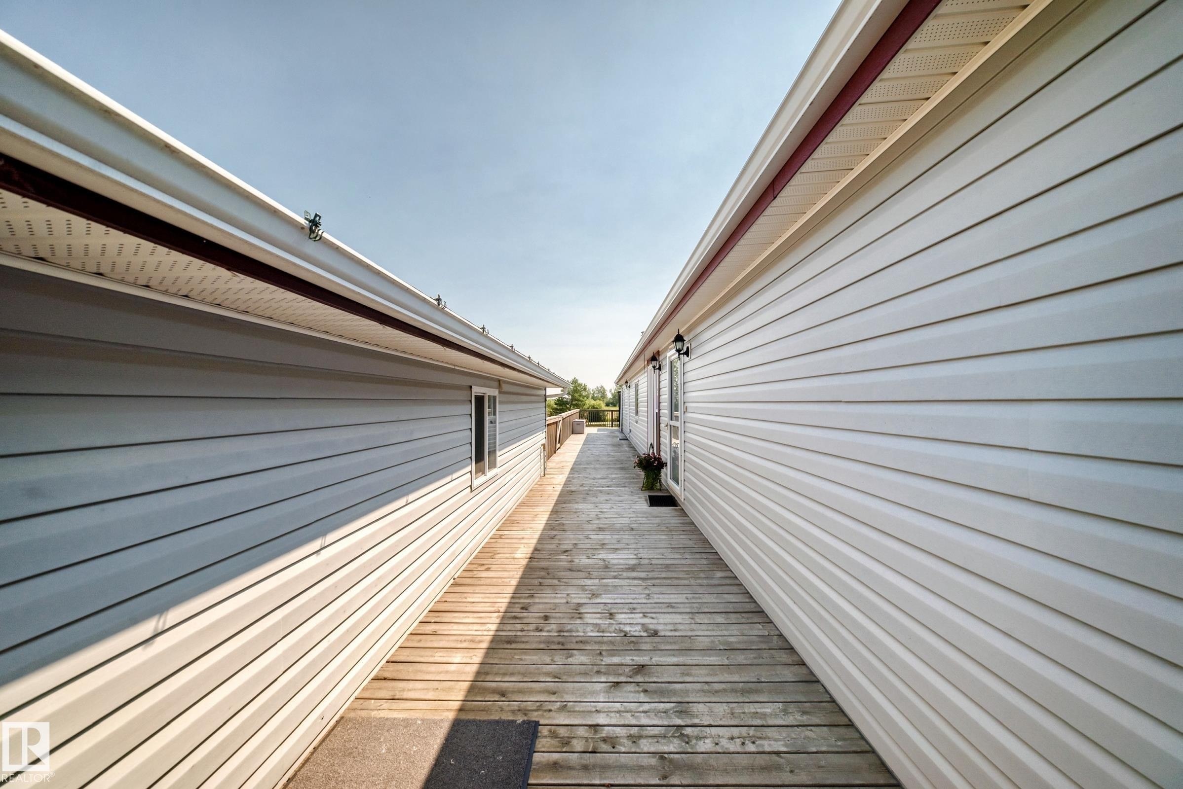 Hardscape wooden walkway between two structures featuring light-colored siding - #225 3400 48 St, Stony Plain, AB - Outdoor With Exterior