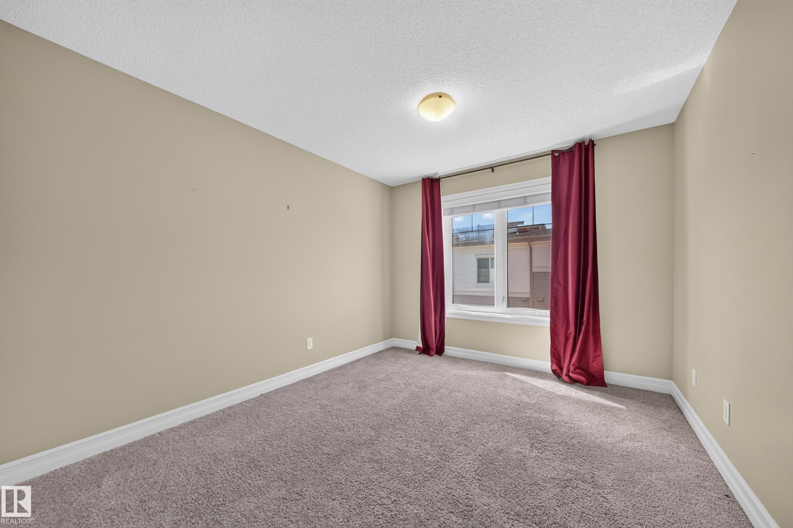 Neutral-toned room with plush carpet flooring and a single window - #100 804 Welsh Dr Sw, Edmonton, AB - Indoor