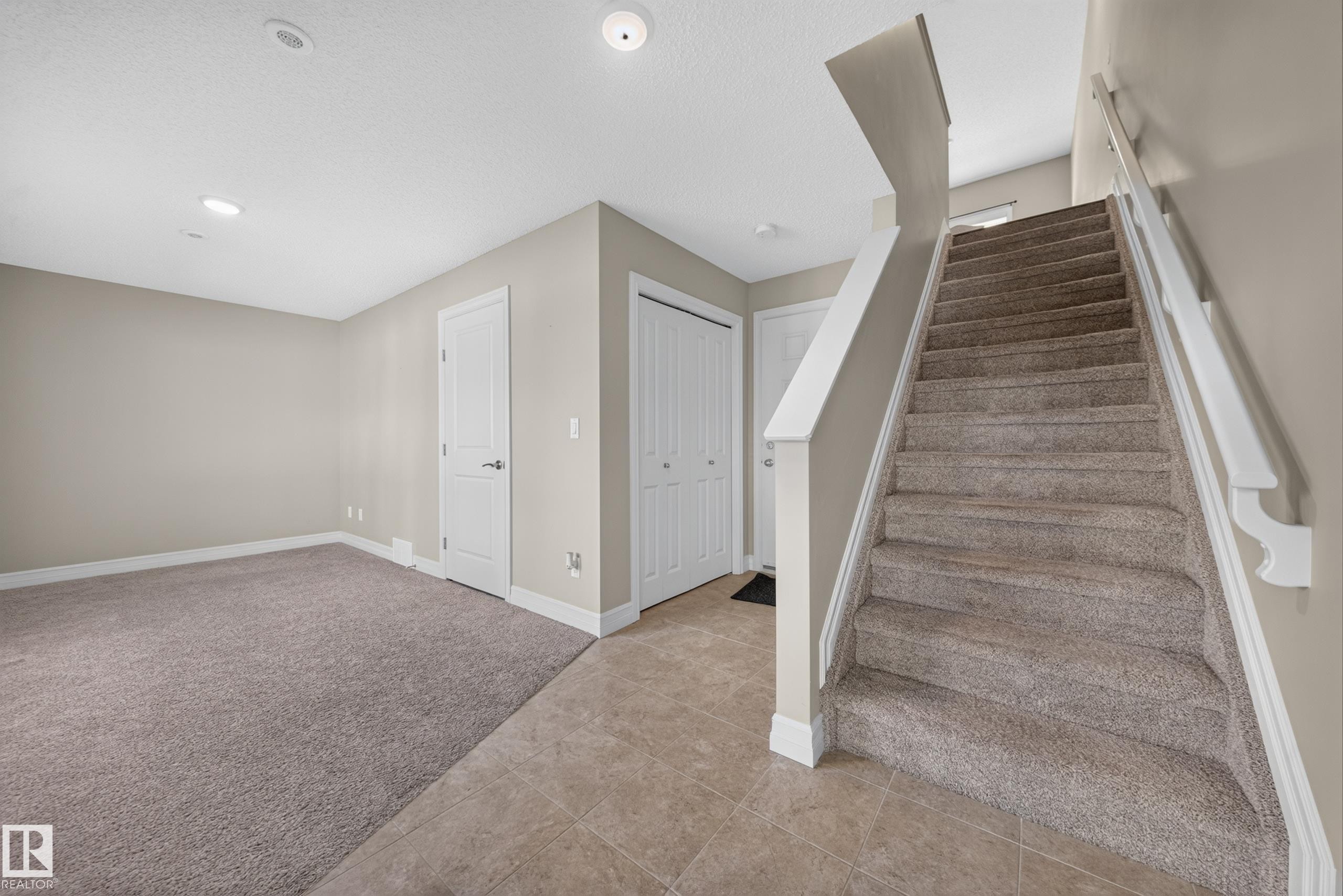 Carpeted staircase with white balusters - #100 804 Welsh Dr Sw, Edmonton, AB - Indoor Photo Showing Other Room