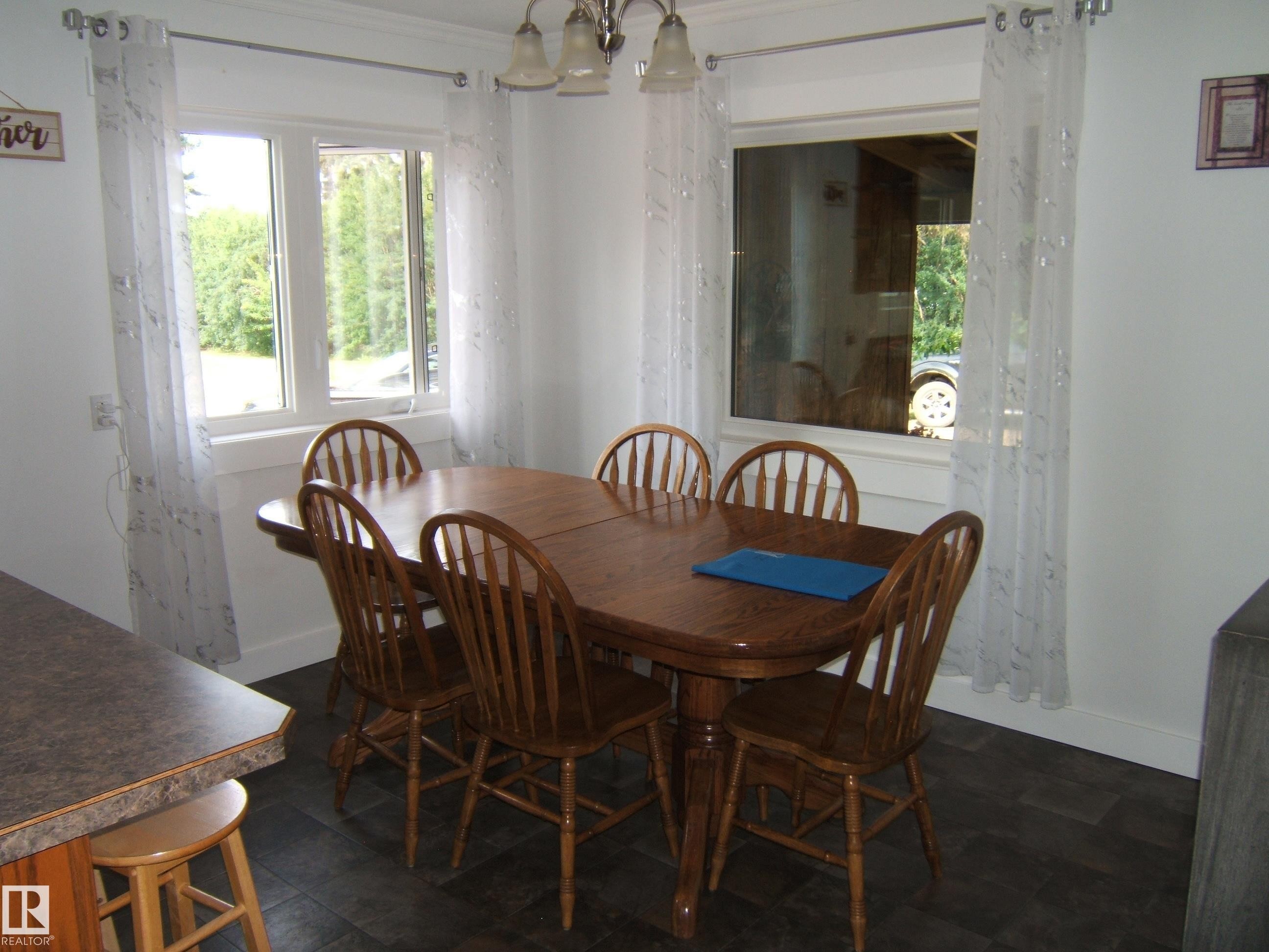 Bright dining area featuring dark wood-finish flooring, white walls, and crown molding - 151042 Twp Rd 562, Rural Two Hills County, AB - Indoor Photo Showing Dining Room