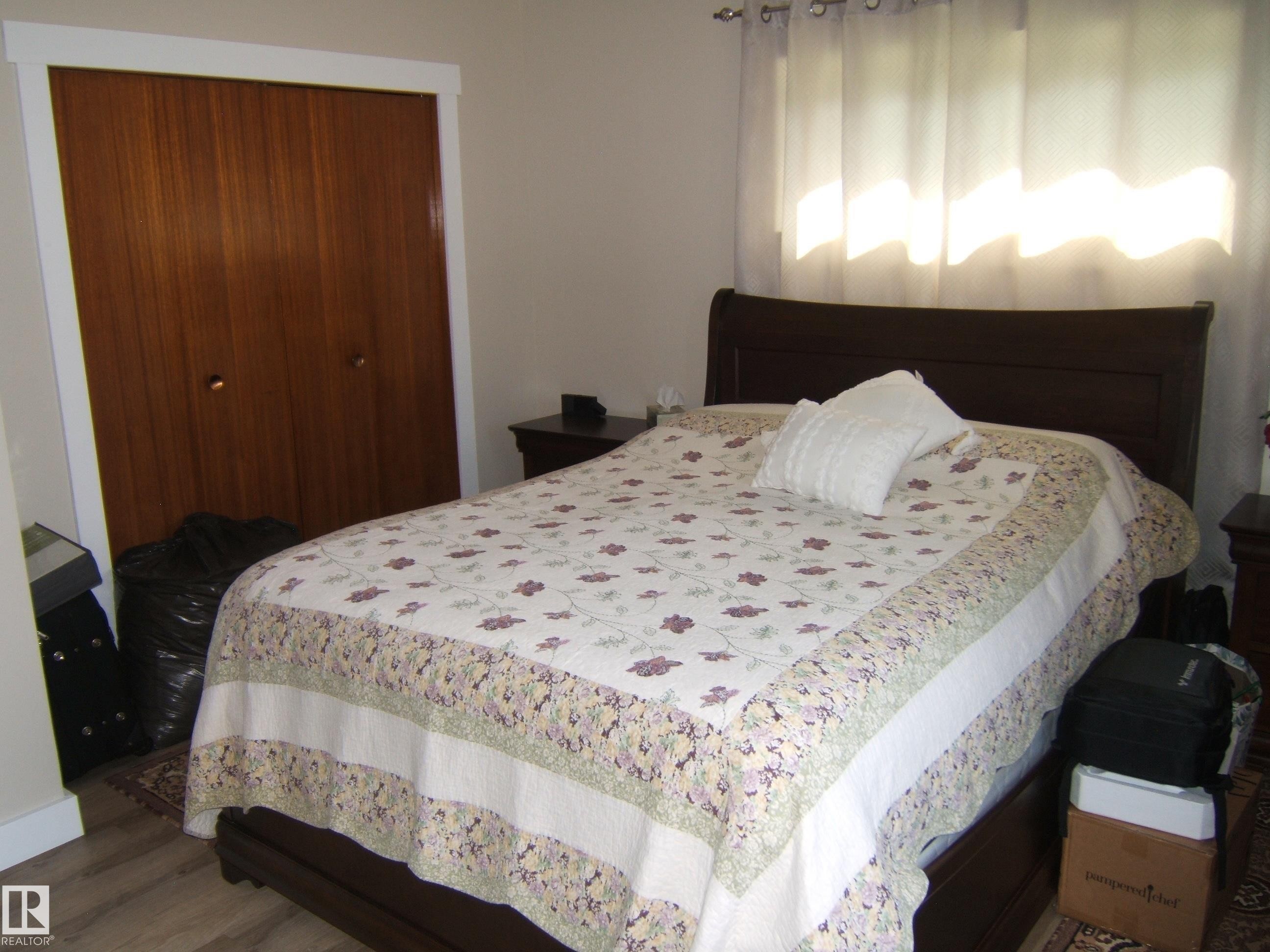 Bedroom featuring wood-finish flooring and a closet with bifold doors - 151042 Twp Rd 562, Rural Two Hills County, AB - Indoor Photo Showing Bedroom