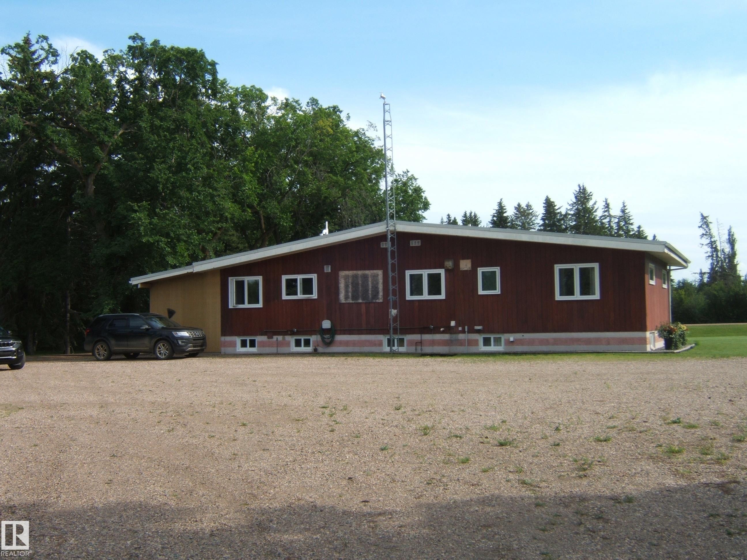Ranch-style residence featuring brown wood siding and white trim - 151042 Twp Rd 562, Rural Two Hills County, AB - Outdoor With Exterior