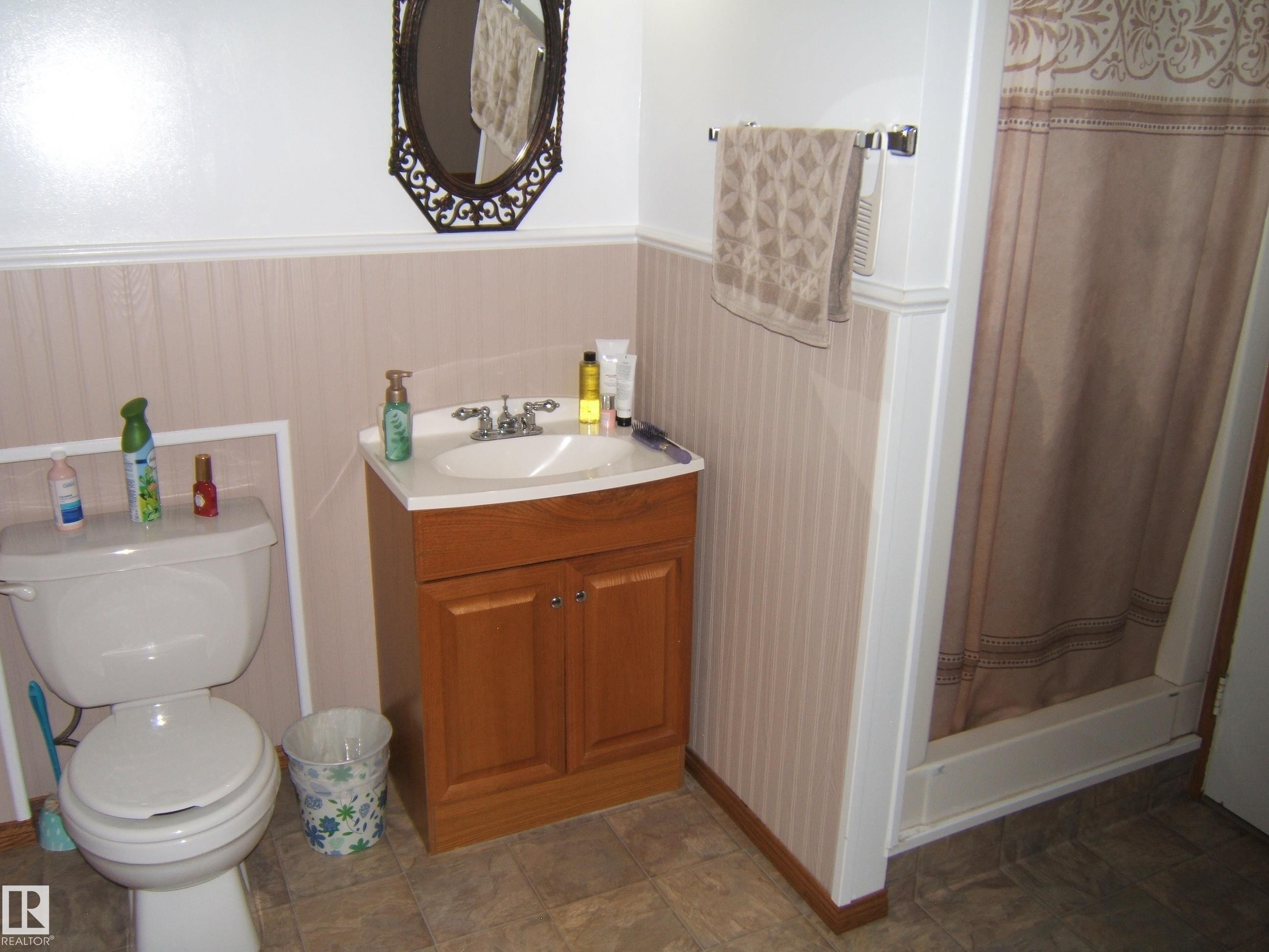 White vanity with an integrated sink and chrome faucet - 151042 Twp Rd 562, Rural Two Hills County, AB - Indoor Photo Showing Bathroom
