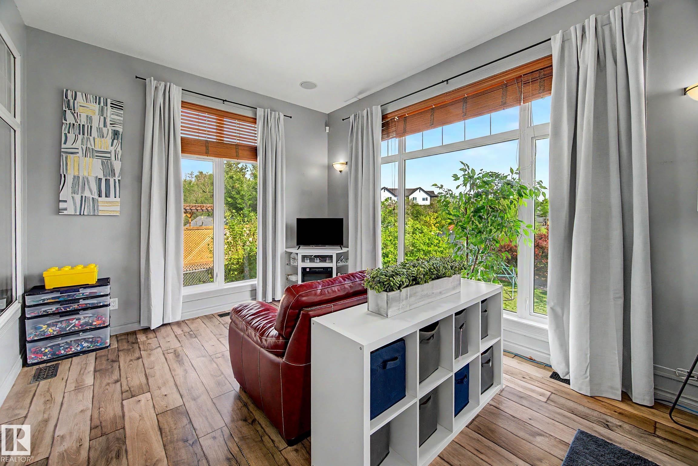 Expansive windows with wood-finish blinds and neutral drapes, complemented by light gray painted walls - 38 Longview Point(E), Spruce Grove, AB - Indoor