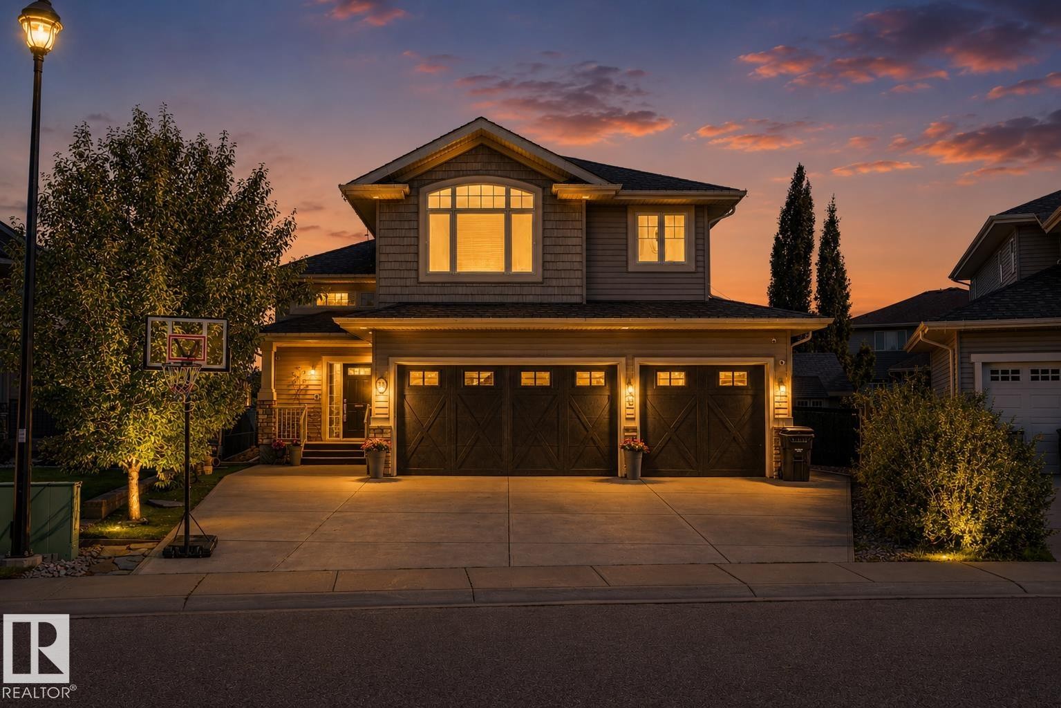 Front exterior with a two-car garage featuring carriage-style doors - 38 Longview Point(E), Spruce Grove, AB - Outdoor