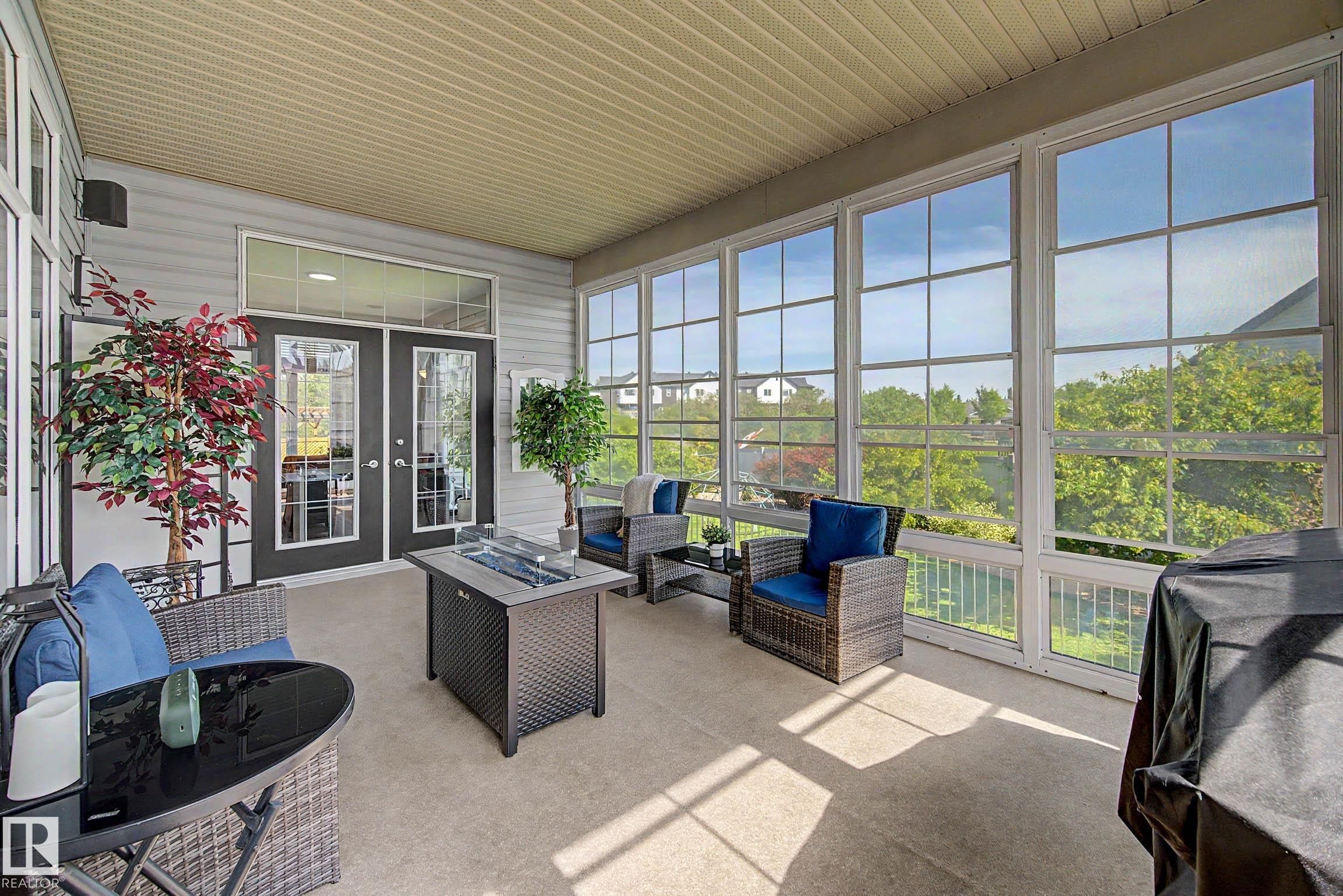 Spacious screened porch featuring a light-colored ceiling, light gray siding, and multiple large windows with white frames - 38 Longview Point(E), Spruce Grove, AB - Outdoor With Deck Patio Veranda With Exterior