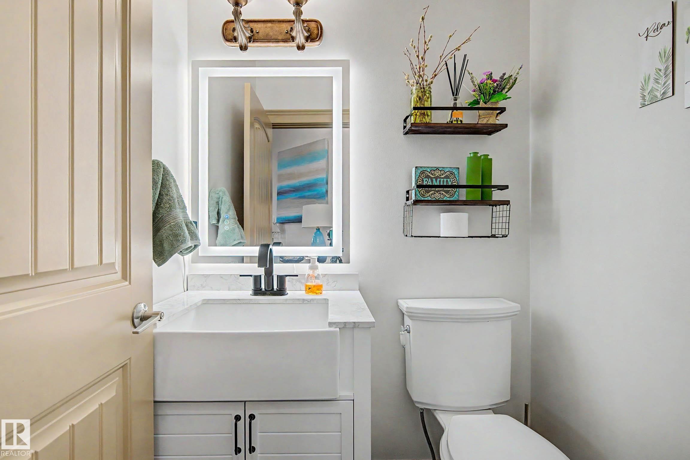 Modern bathroom featuring a white farmhouse-style sink, quartz countertop, and black matte faucet - 38 Longview Point(E), Spruce Grove, AB - Indoor Photo Showing Bathroom