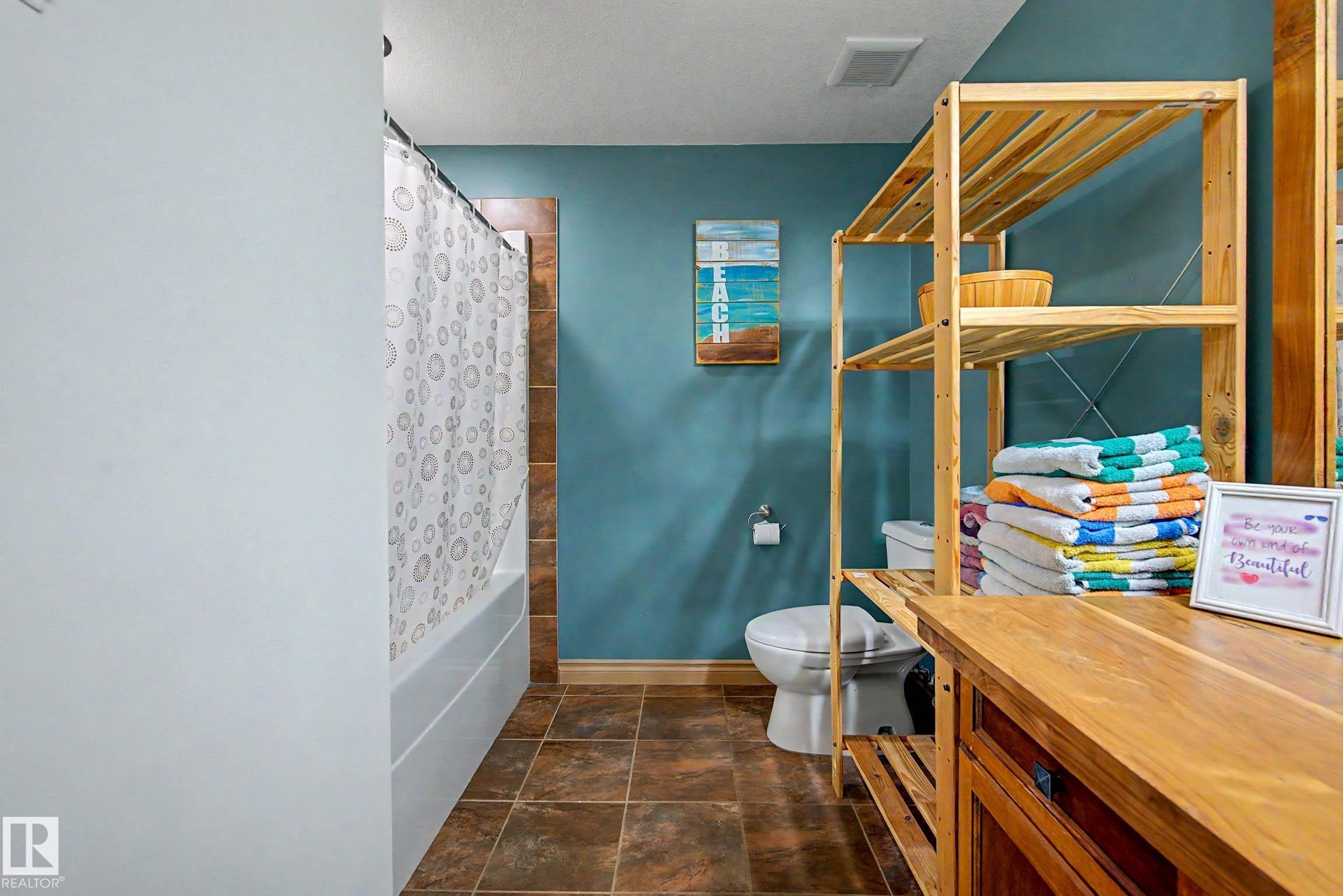 Bathroom with tile flooring and a bathtub shower combination featuring a tiled surround - 38 Longview Point(E), Spruce Grove, AB - Indoor