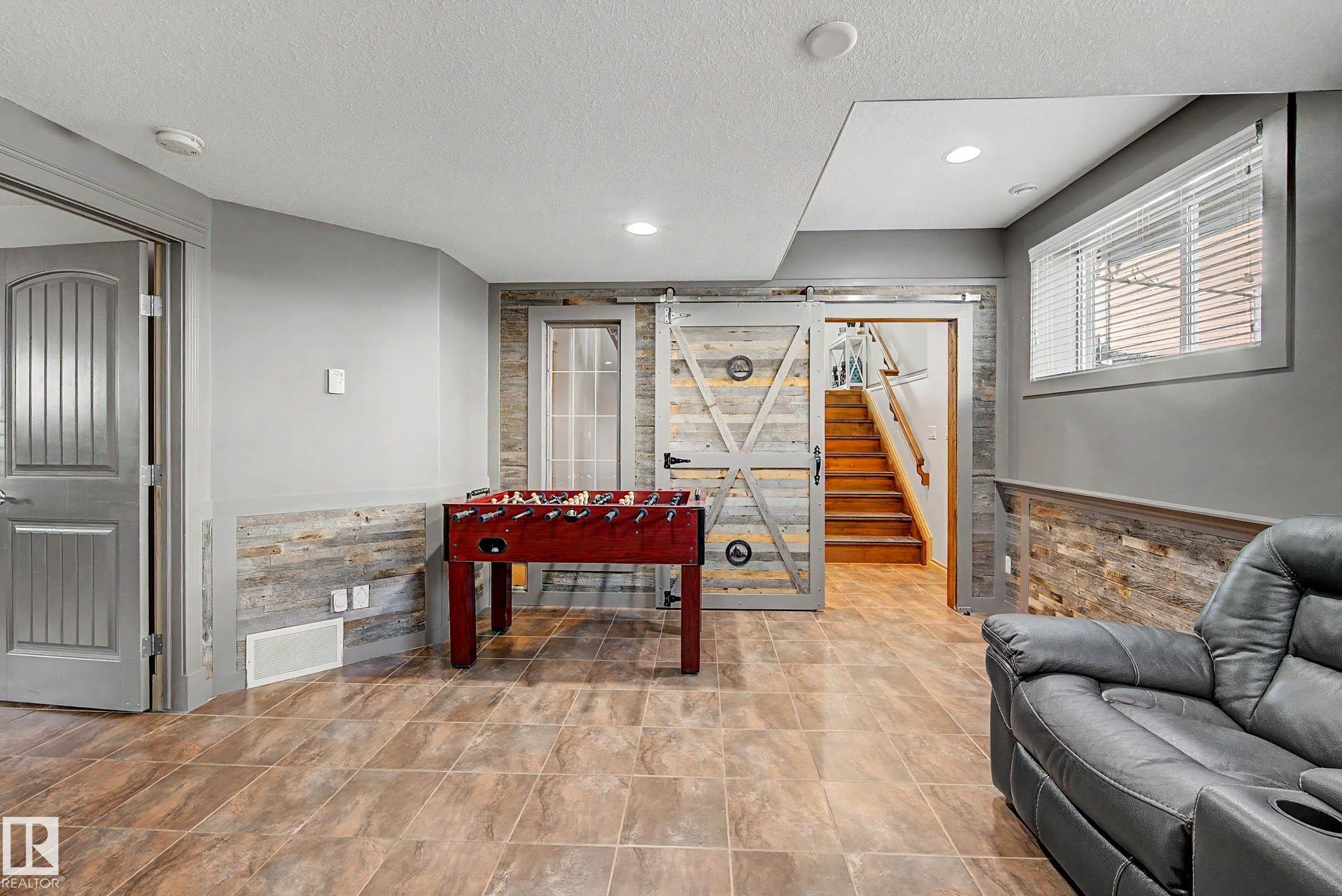 Finished lower level featuring large format tile flooring, recessed lighting, and accent wall paneling - 38 Longview Point(E), Spruce Grove, AB - Indoor