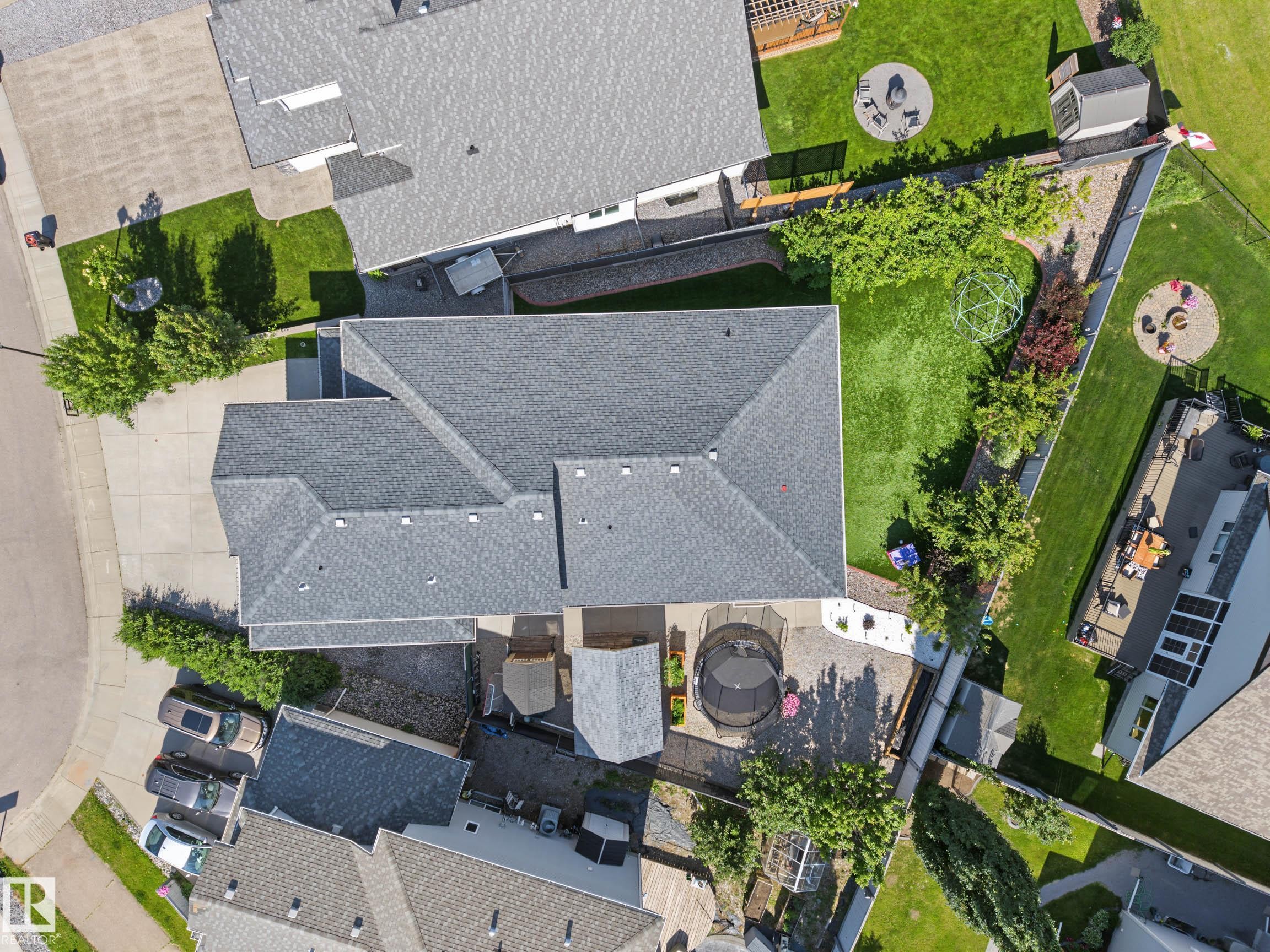 Expansive property featuring a paved driveway, a large private yard with manicured lawn, and mature perimeter trees - 38 Longview Point(E), Spruce Grove, AB - Outdoor