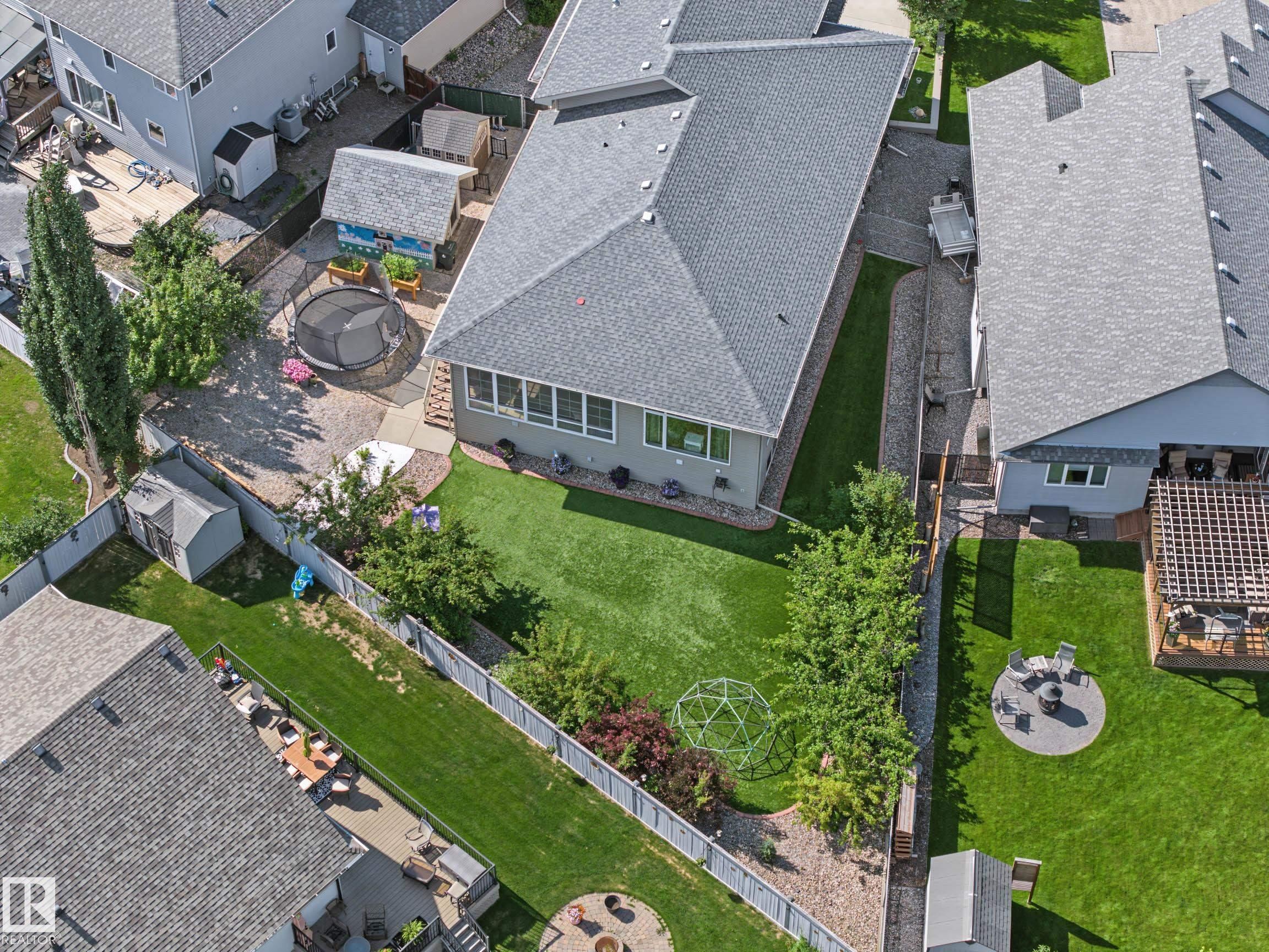Expansive backyard featuring a manicured lawn, paved patio area, and established plantings - 38 Longview Point(E), Spruce Grove, AB - Outdoor