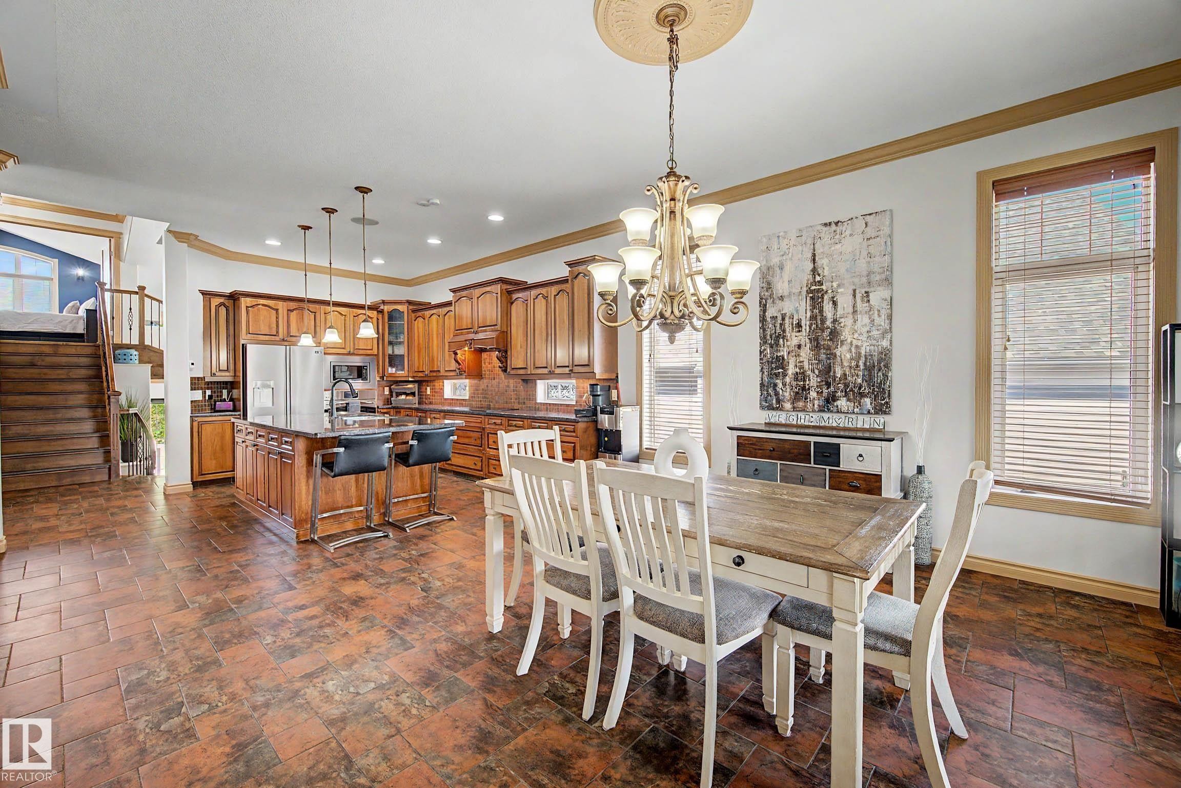 Open-concept living space featuring a spacious kitchen with wood cabinetry and a central island - 38 Longview Point(E), Spruce Grove, AB - Indoor Photo Showing Dining Room