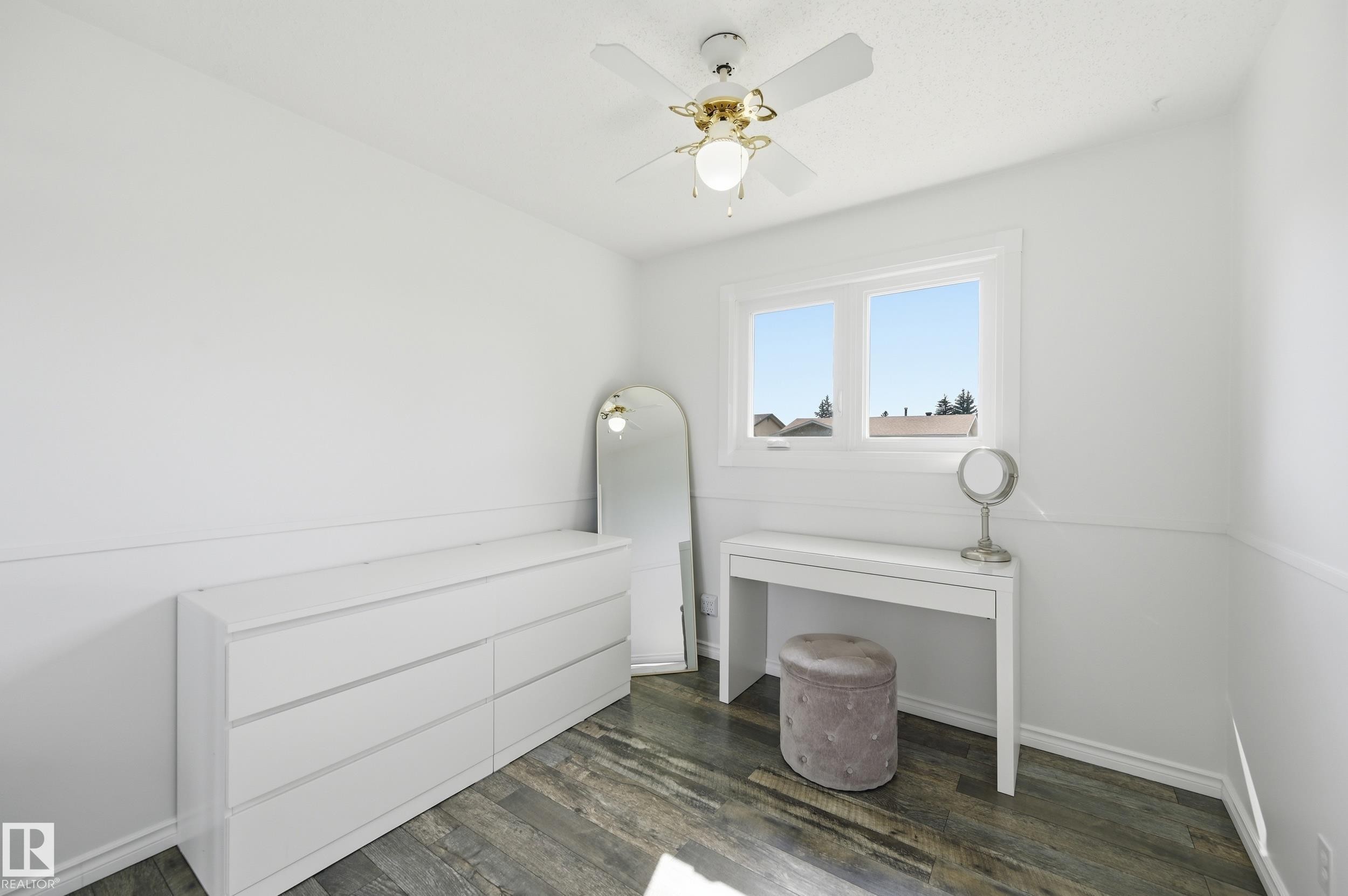 Bright room featuring wood-finish flooring, white walls, and a white window frame - 15111 67 Street Nw, Edmonton, AB - Indoor