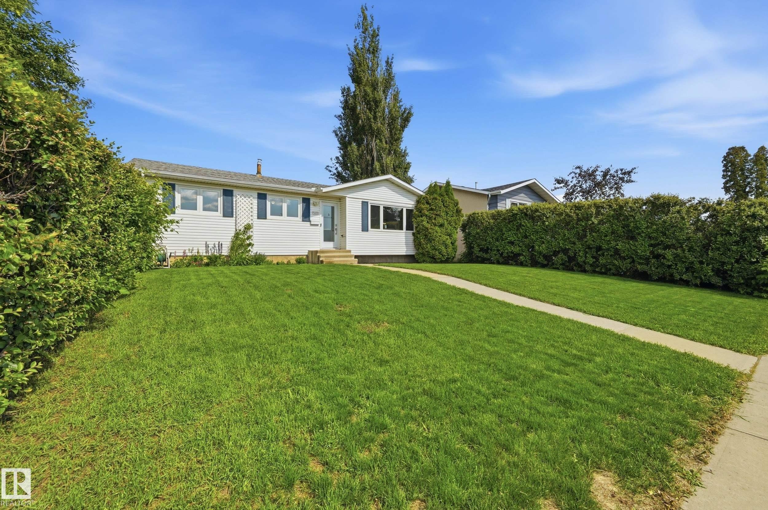 Single-story residence featuring white siding, dark shutters, and a prominent front lawn - 15111 67 Street Nw, Edmonton, AB - Outdoor