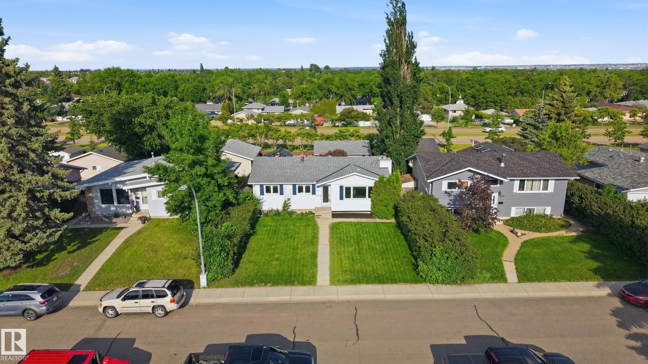Single-story residence featuring white siding, a dark roof, and blue shutters - 15111 67 Street Nw, Edmonton, AB - Outdoor