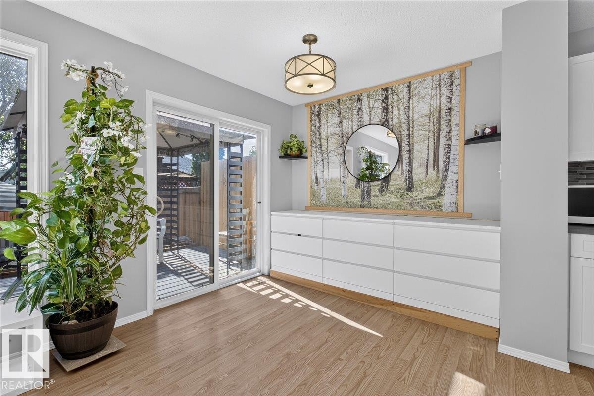 Sliding glass patio door with wood-finish flooring - #18 345 Kirkness Rd Nw, Edmonton, AB - Indoor Photo Showing Other Room
