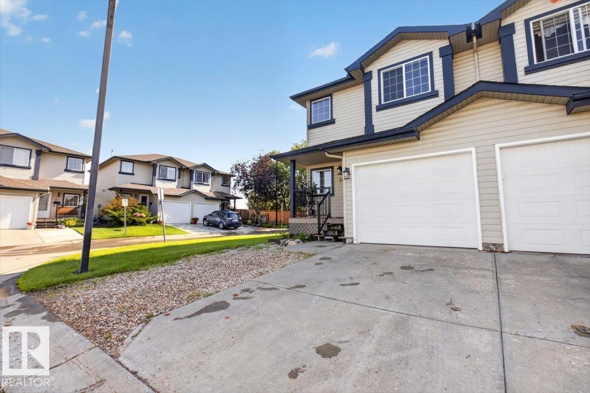 Two-story exterior with light-toned siding and dark trim - #18 345 Kirkness Rd Nw, Edmonton, AB - Outdoor