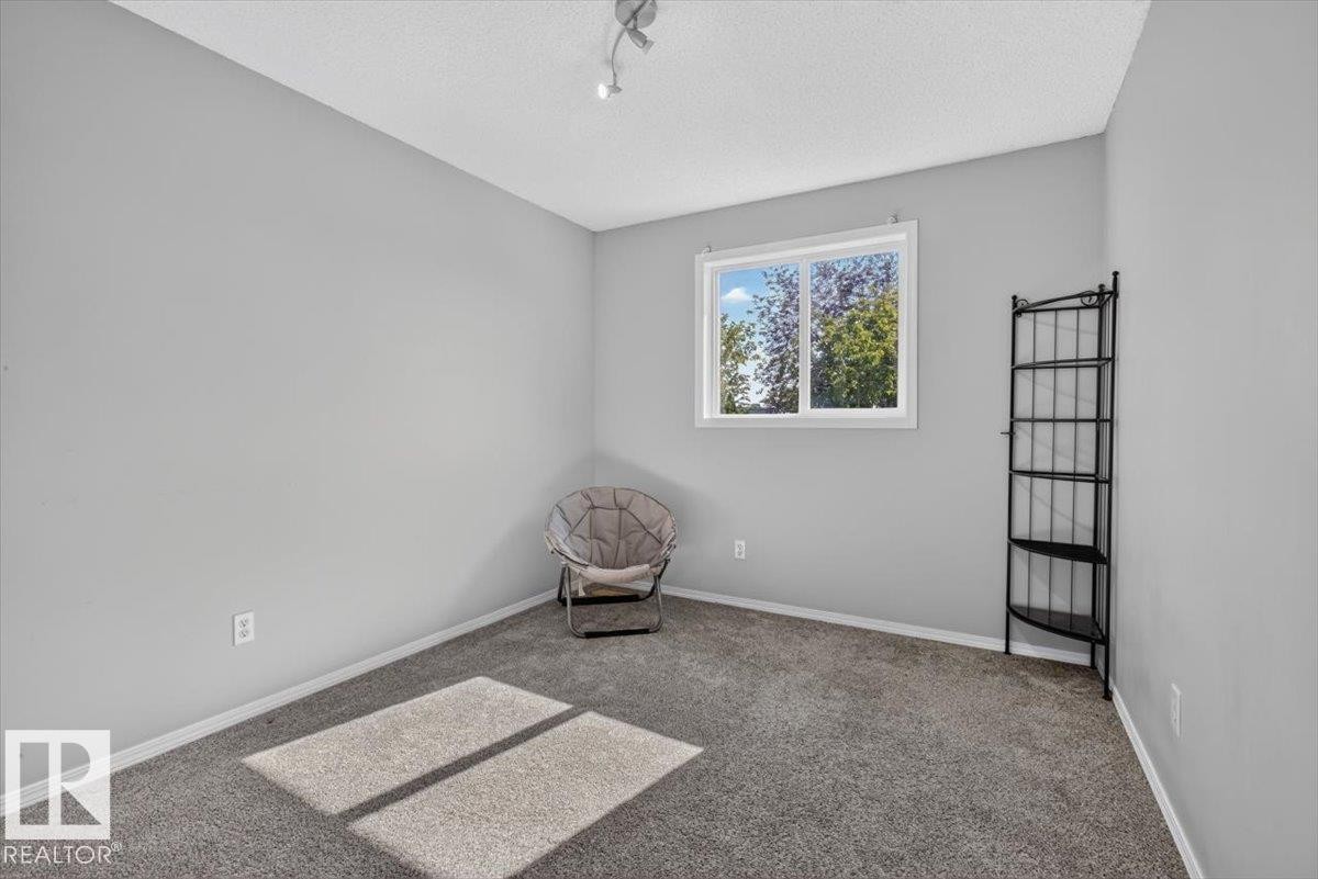 Room featuring light gray walls, gray carpeting, and a white window frame - #18 345 Kirkness Rd Nw, Edmonton, AB - Indoor