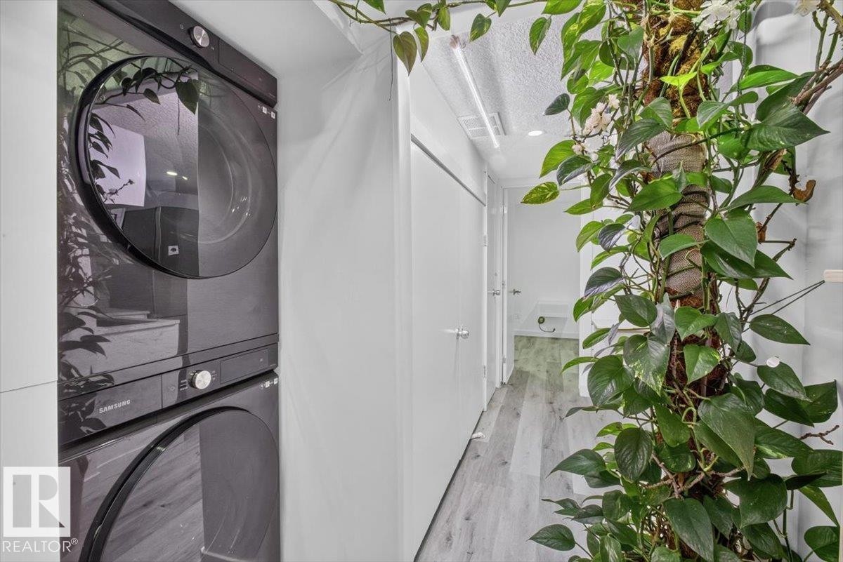 Vertical laundry appliances with front-loading design - #18 345 Kirkness Rd Nw, Edmonton, AB - Indoor Photo Showing Laundry Room