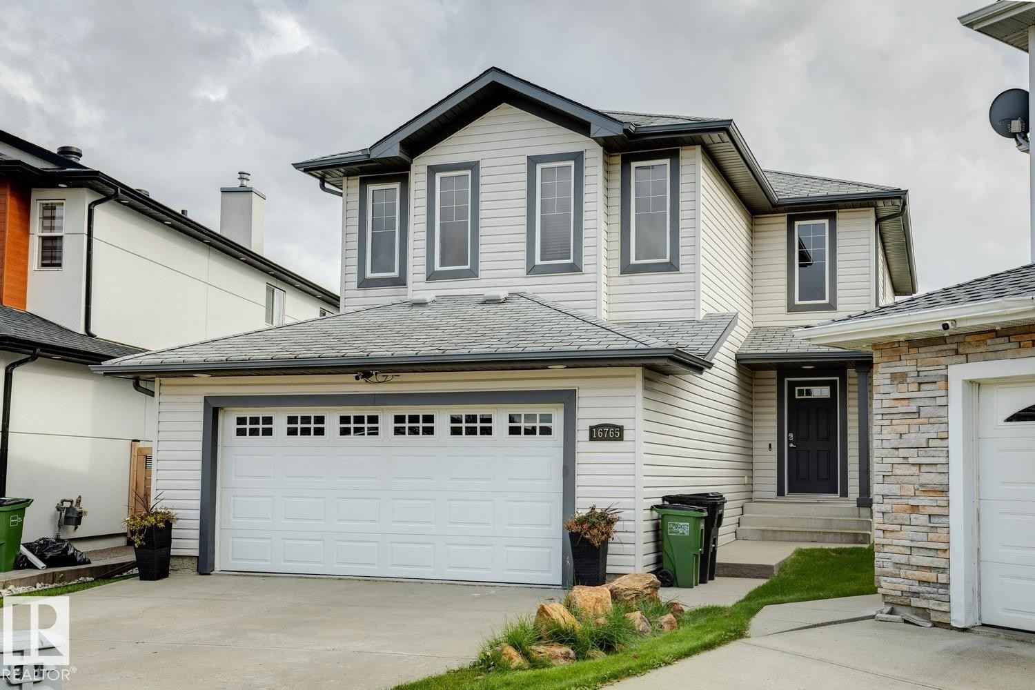 Two-story home featuring light-colored siding and dark trim - 16765 119 Street Nw, Edmonton, AB