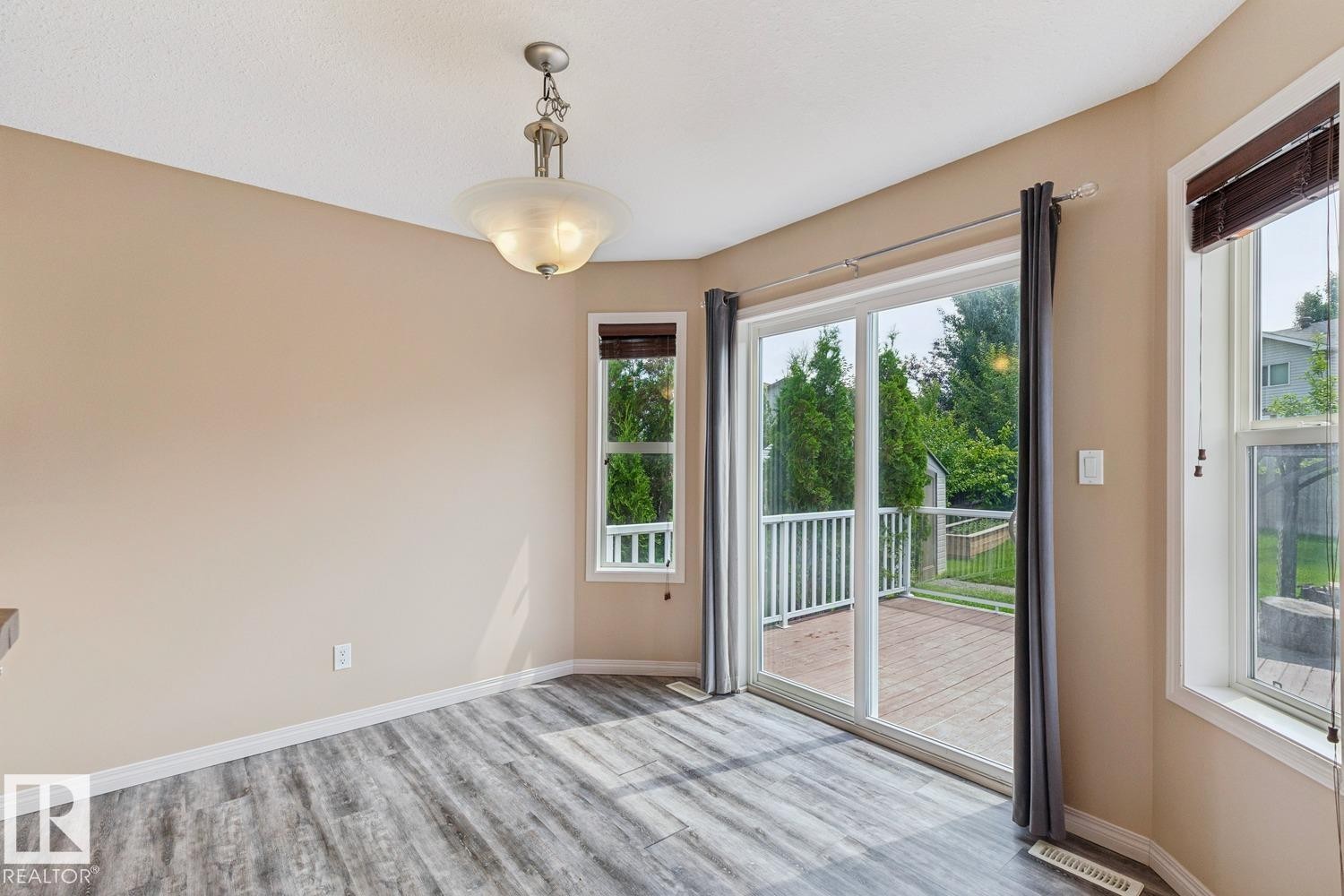 Room featuring wood-finish flooring, neutral wall tones, and a contemporary ceiling light fixture - 16765 119 Street Nw, Edmonton, AB