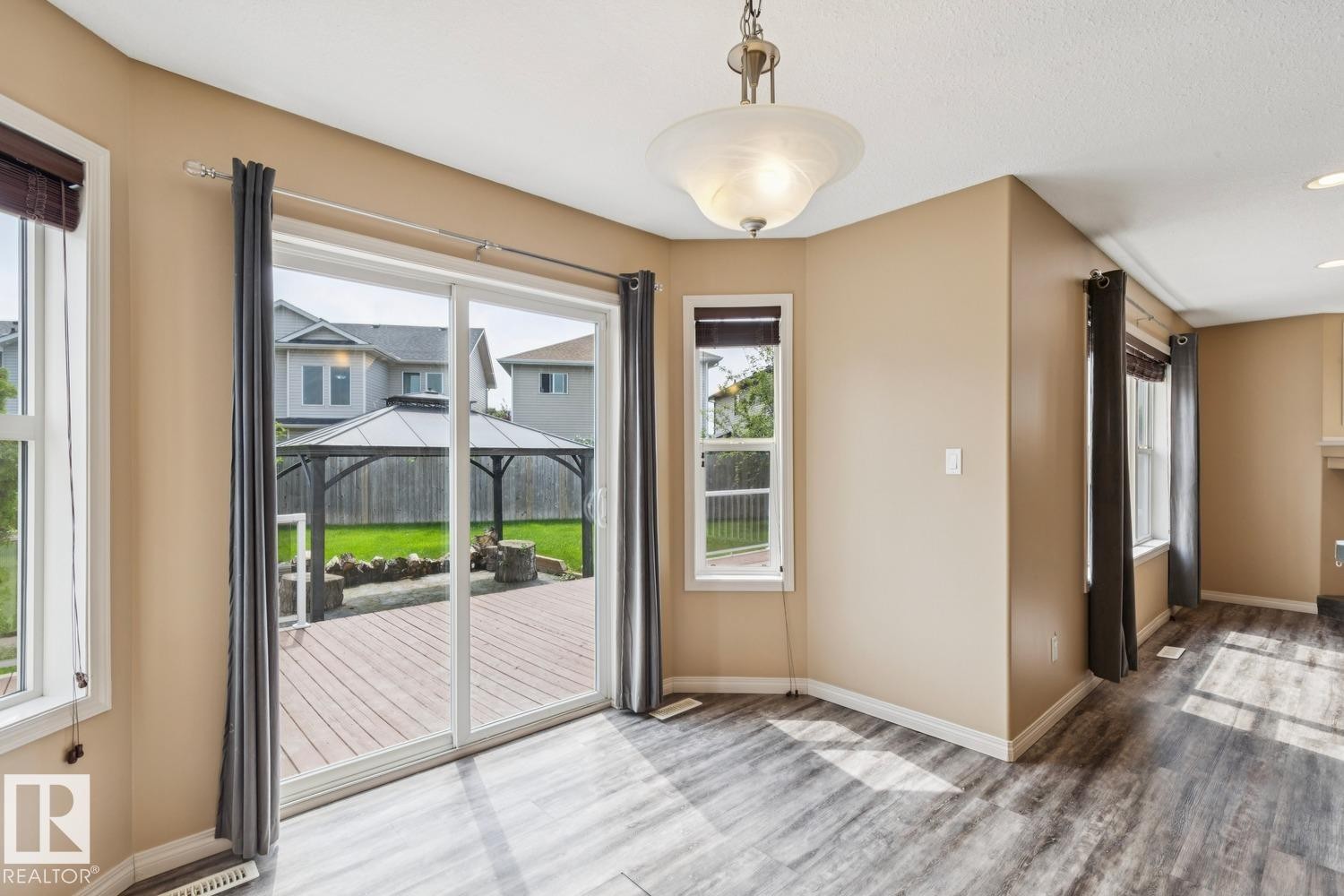 Sliding glass doors opening to an expansive wooden deck - 16765 119 Street Nw, Edmonton, AB