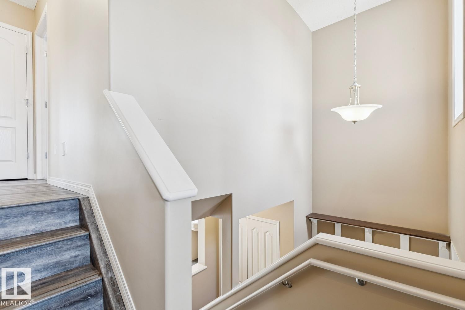 Multi-level interior featuring a vaulted ceiling and a hanging chandelier - 16765 119 Street Nw, Edmonton, AB
