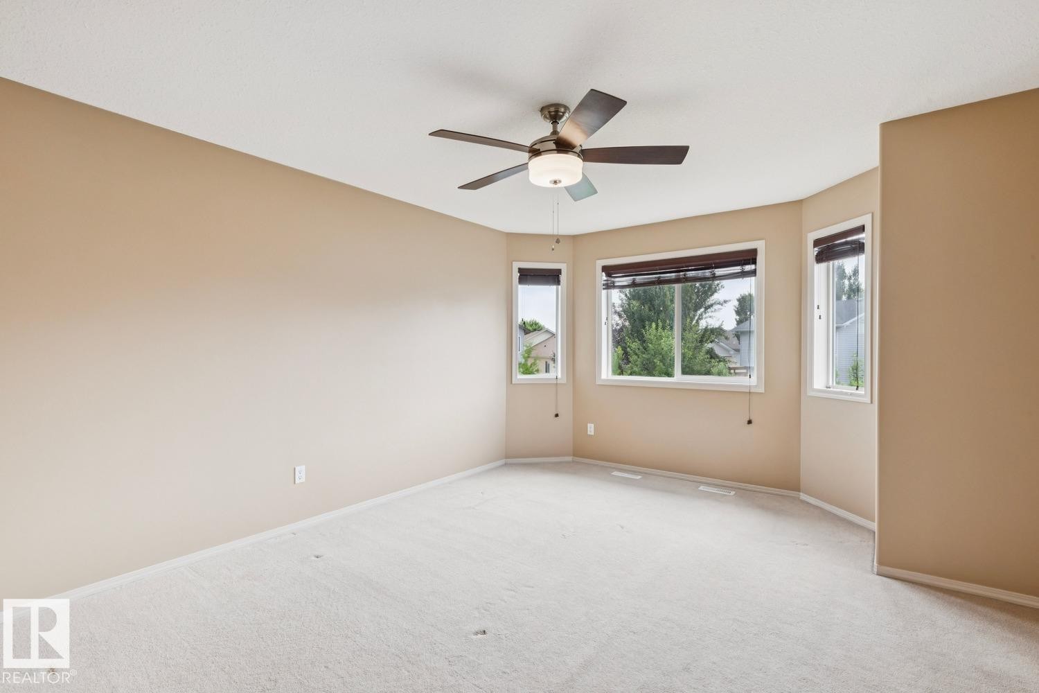 Spacious room featuring light neutral wall paint and light-colored carpeting - 16765 119 Street Nw, Edmonton, AB