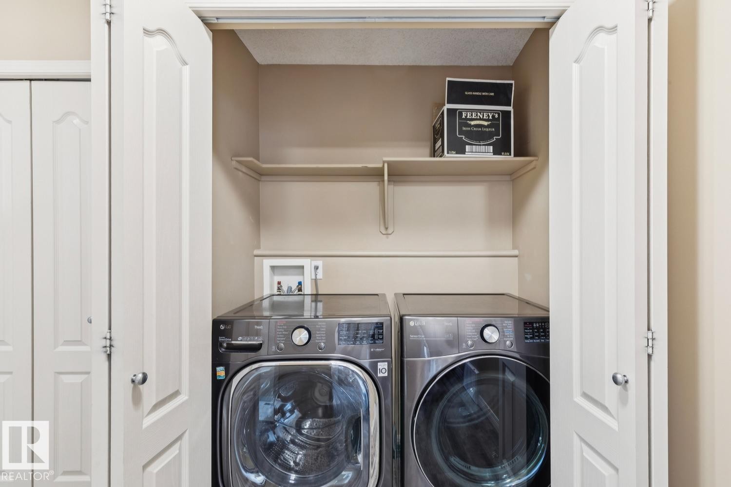Dedicated laundry closet featuring bi-fold doors, upper shelving, and utility hookups - 16765 119 Street Nw, Edmonton, AB
