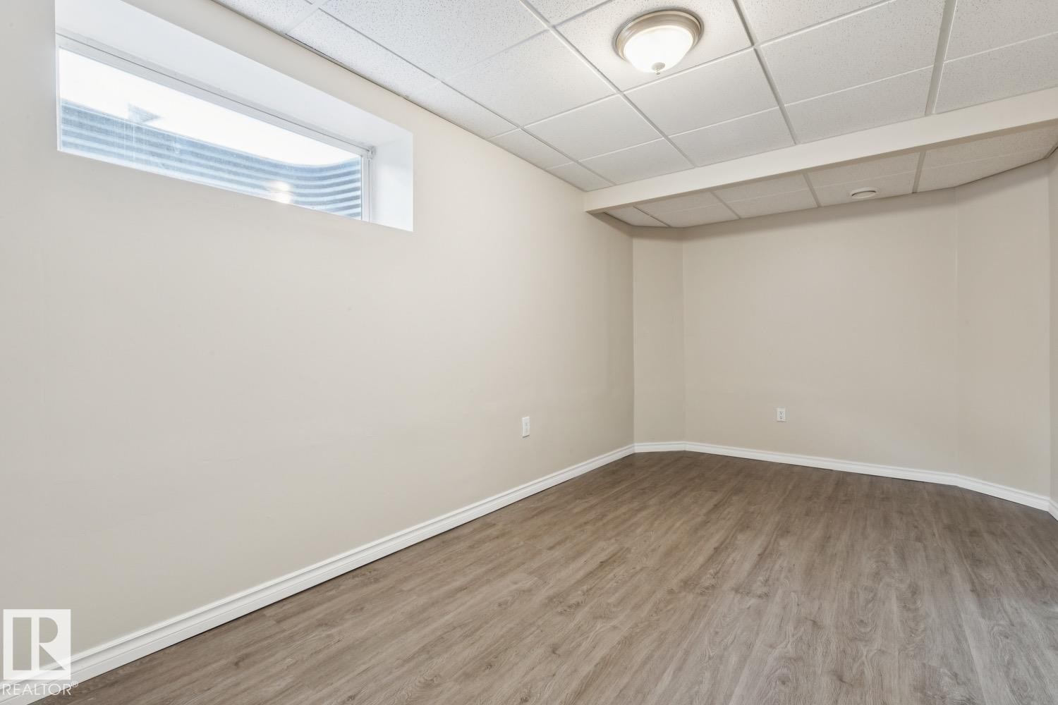 Recessed window, wood-finish flooring, drop ceiling, flush mount lighting, neutral wall tones - 16765 119 Street Nw, Edmonton, AB