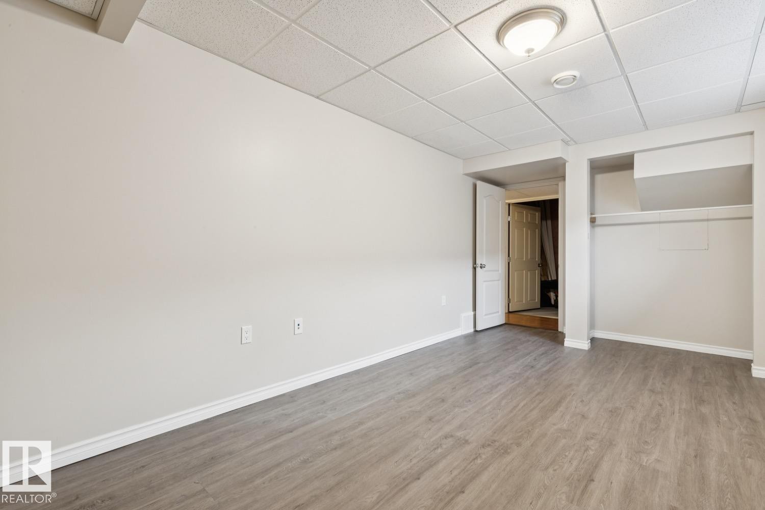 Drop ceiling with recessed lighting, wood-finish flooring, and an open closet - 16765 119 Street Nw, Edmonton, AB
